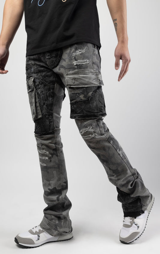 Black camo Extended length flare pant with a regular rise for maximum stacks. Skinny fit with hand-smearing and speckled paint splatter throughout. Rip and repair detailing, accompanied by cut & sewn woodland camouflage twill patches. Stitching repairs and deep front pocket bags, perfect for large smart phones.