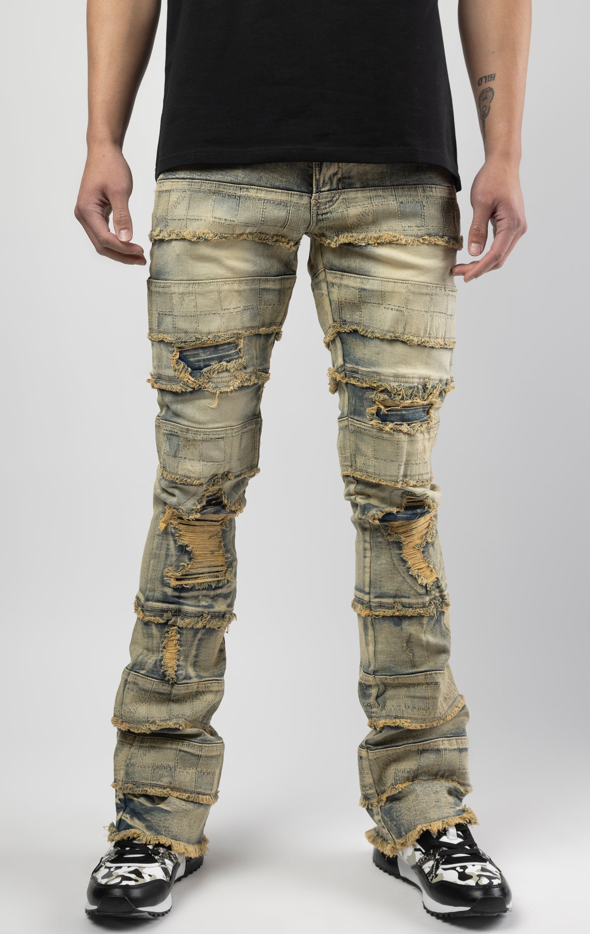 Dirt wash iconic stacked jeans crafted from high-quality, durable denim fabric consisting of 98% cotton and 2% spandex with a semi flare silhouette and a length of 35"-37". Featuring a distinctive ripped and repair design with pocket patches and a multi-tone dye throughout, these urban-inspired pants are true to size
