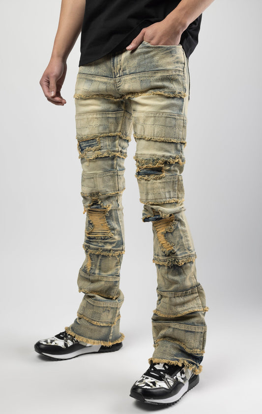 Dirt wash iconic stacked jeans crafted from high-quality, durable denim fabric consisting of 98% cotton and 2% spandex with a semi flare silhouette and a length of 35"-37". Featuring a distinctive ripped and repair design with pocket patches and a multi-tone dye throughout, these urban-inspired pants are true to size
