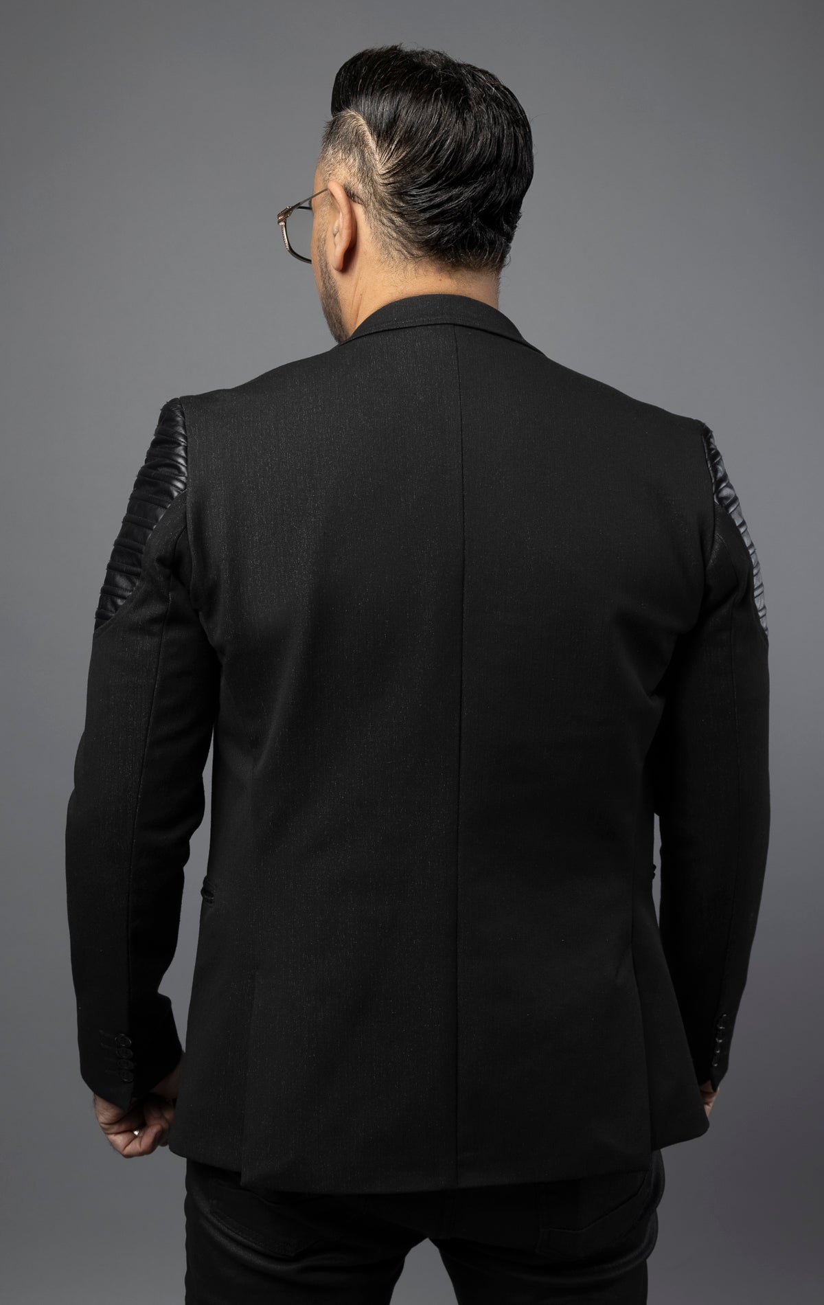 Structured construction with a modern notch lapel and zipper closure for a sleek look. Zipper pockets on the sides and chest, along with moto-inspired patches on the shoulders, add a touch of edginess. The slim fit is complemented by 4 non-functional button cuffs, and the double vented design completes the fully lined jacket.