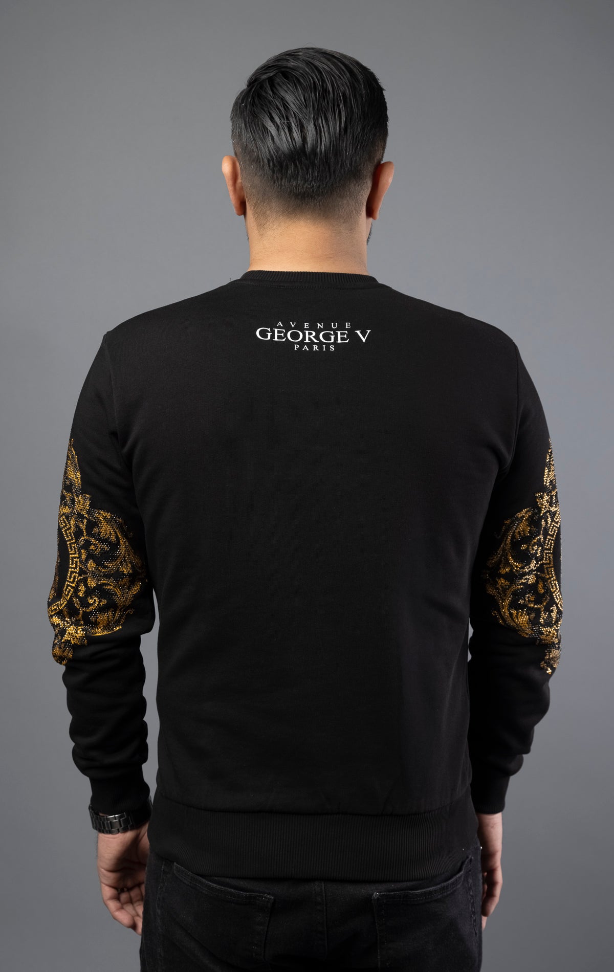 Black Soft and comfortable GV sweater with round-neck, long sleeves, and a Lion pin. The gold sleeves add a touch of elegance, making it suitable for daily wear. Made with soft cotton for ultimate comfort.