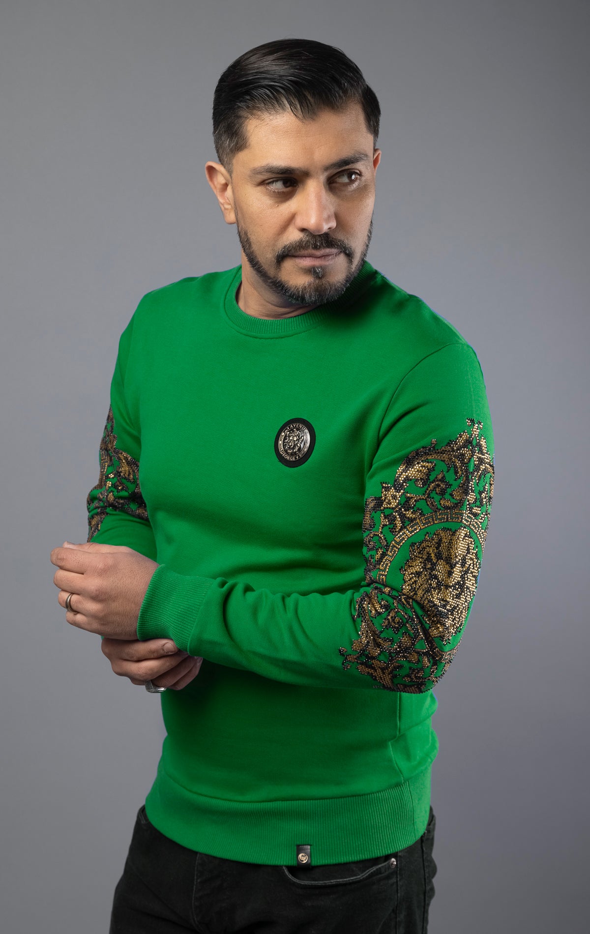 Green Soft and comfortable GV sweater with round-neck, long sleeves, and a Lion pin. The gold sleeves add a touch of elegance, making it suitable for daily wear. Made with soft cotton for ultimate comfort.