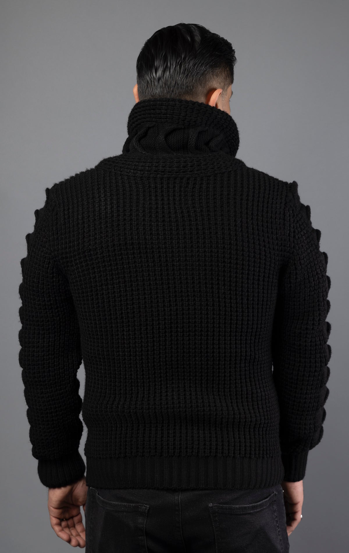 Model wearing black versatile, high-quality sweater designed with heavy weight material to be worn in multiple ways