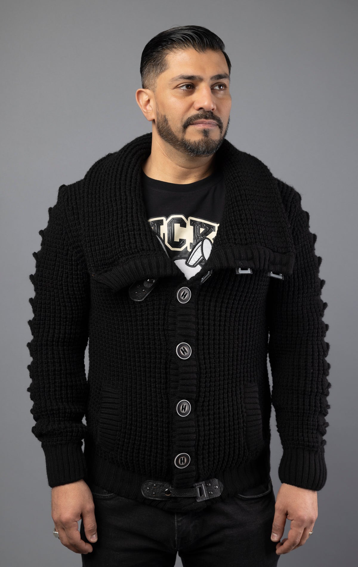 Model wearing black versatile, high-quality sweater designed with heavy weight material to be worn in multiple ways