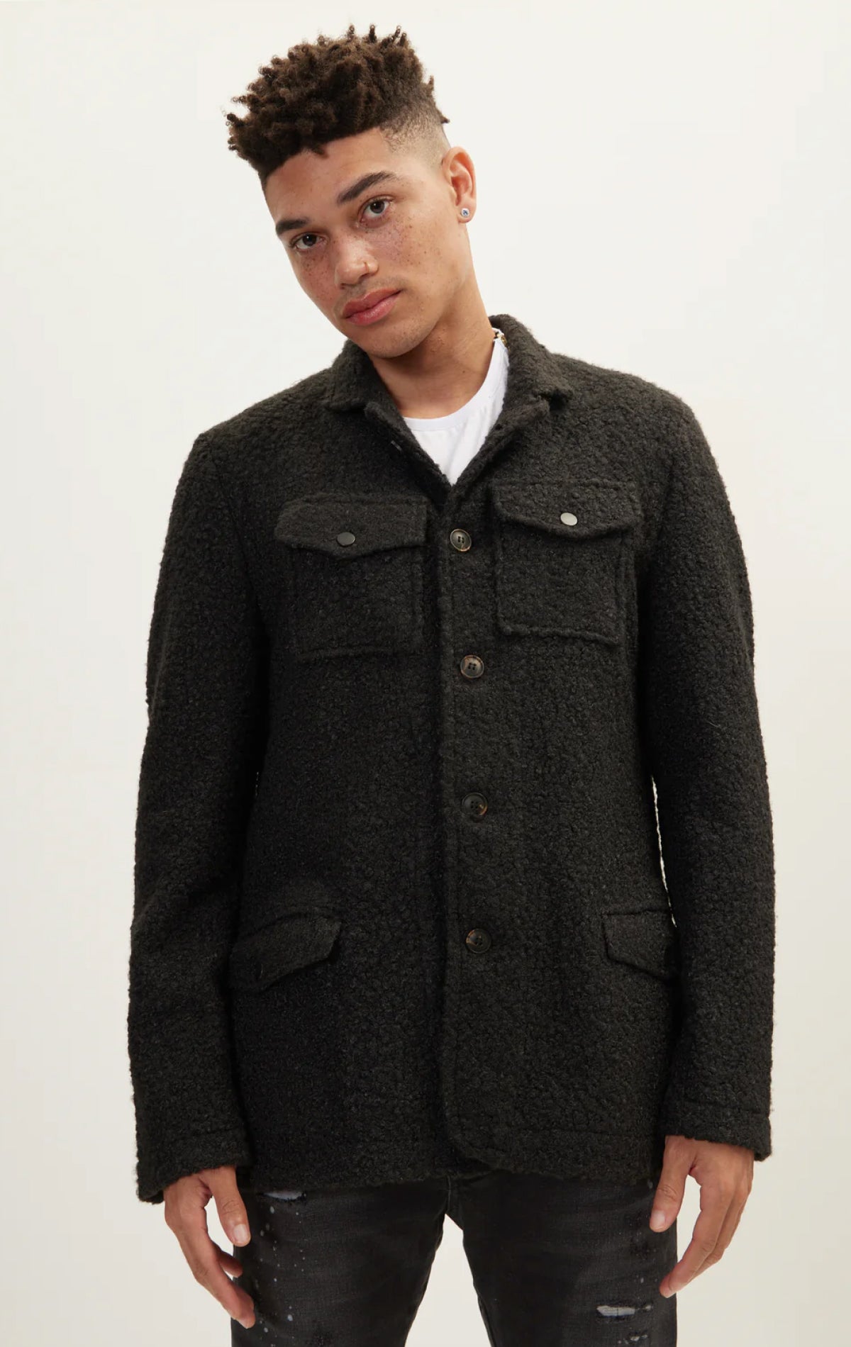 Black overshirt boasts a faux teddy material and oversized fit, complete with a soft lining, and chest pockets.