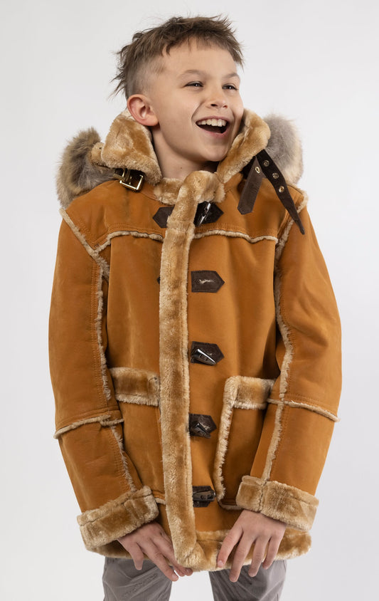 Cognac jacket lined with plush faux shearling throughout the body and sleeves. It also features shearling-accented pockets, a horn toggle front closure, and vegan suede straps with a buckle at the neck. For added convenience, a detachable faux fox fur hood with a zipper is included. This product is also available for adults.