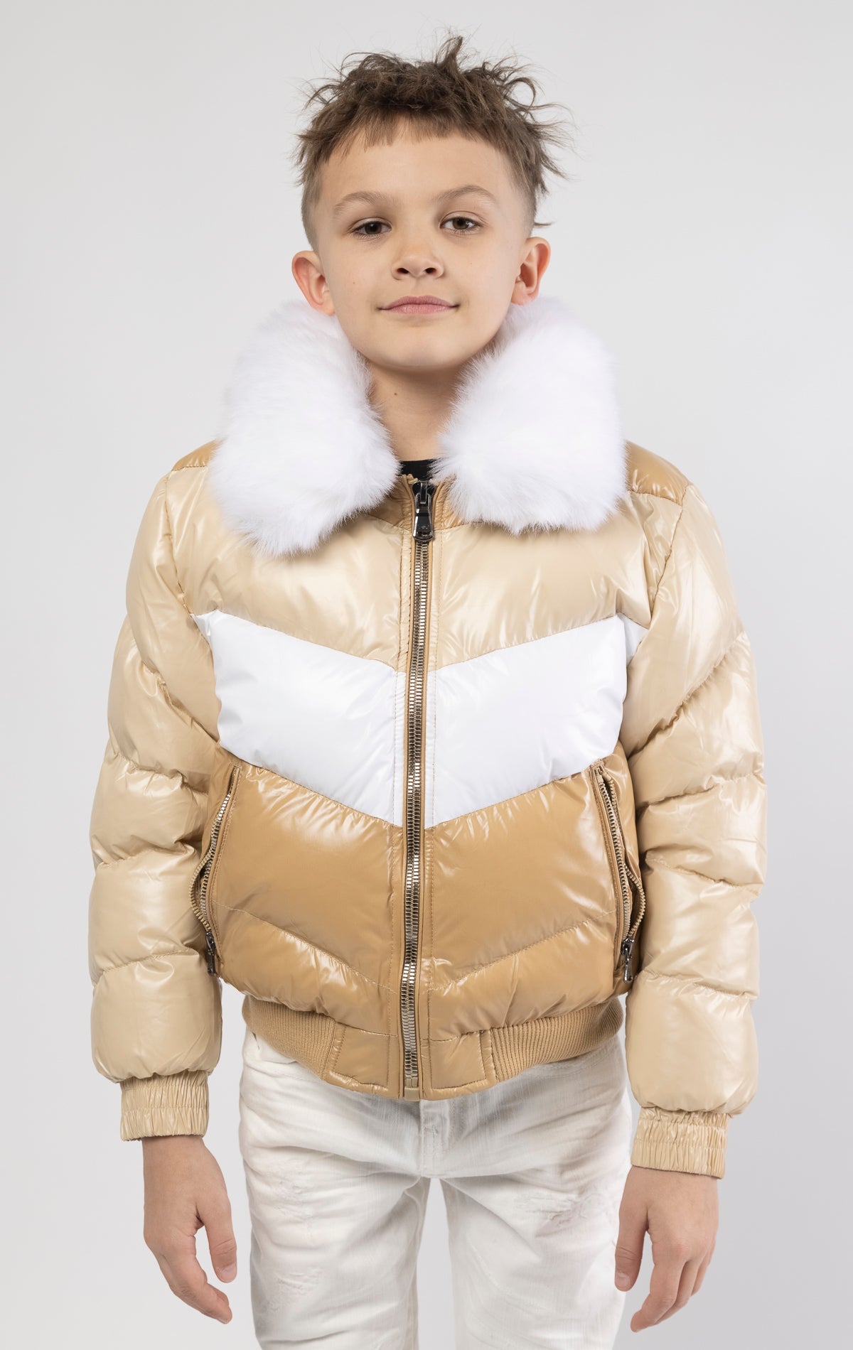 This kids' puffer jacket features a 100% nylon laqué shell, quilted padding, and 100% polyester lining. It also includes branded Jordan Craig zippers, dual side pockets with zipper closure, and a removable faux jackal fur collar.