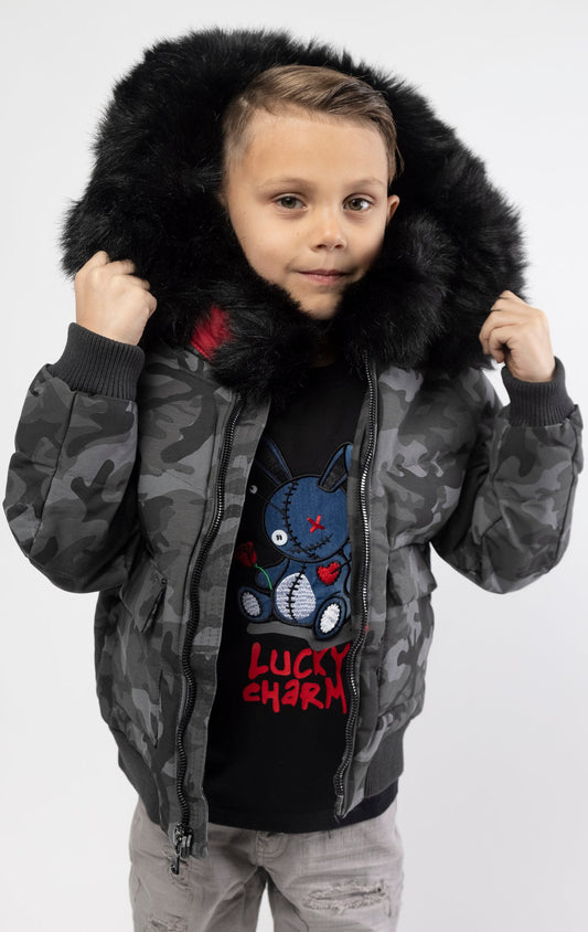 Full zip bomber jacket silhouette, with quilted padding and dense insulation for extreme warmth. Made with 100% polyester lining and featuring a removable faux jackal fur collar and hood. Available in woodland and black camo.