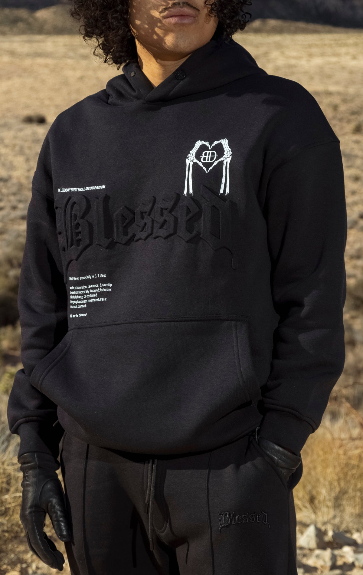 Black hoodie with a 3D embossed "blessed" logo and hood pop-stud.