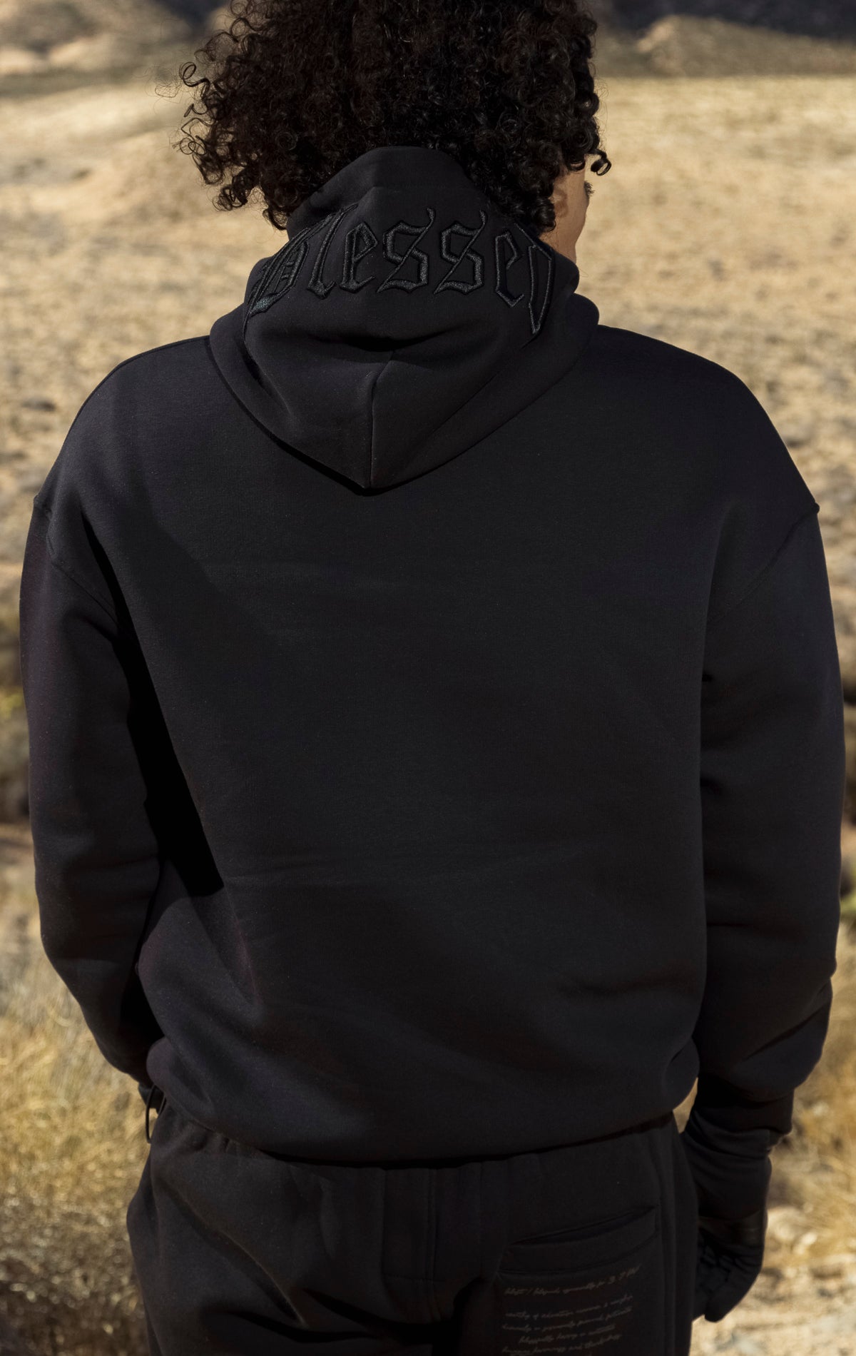 Black hoodie with a 3D embossed "blessed" logo and hood pop-stud.