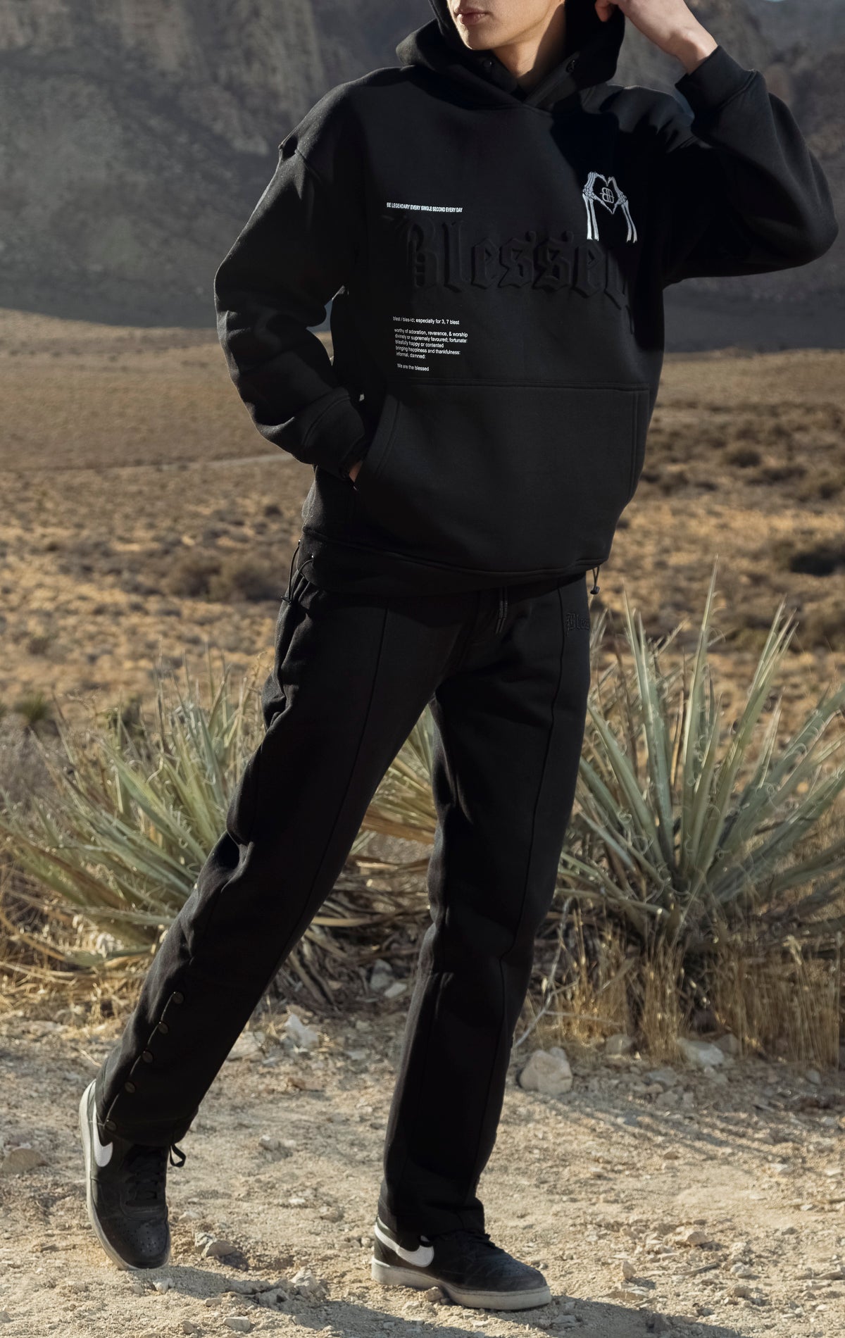 Black hoodie and joggers with a 3D embossed "blessed" logo and hood pop-stud.