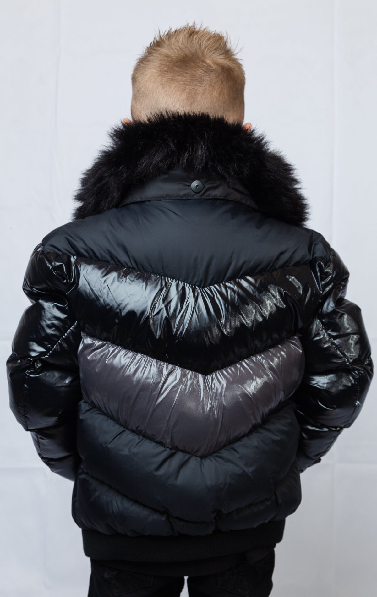 This  kids' puffer jacket features a 100% nylon laqué shell, quilted padding, and 100% polyester lining. It also includes branded Jordan Craig zippers, dual side pockets with zipper closure, and a removable faux jackal fur collar. 