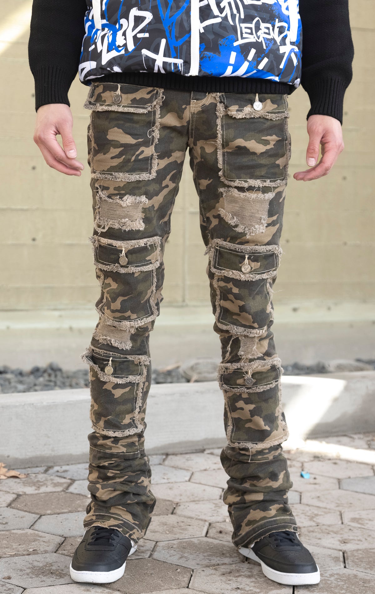 Camo super stacked jeans featuring an extra-long inseam and flared leg opening with distressing, stone washing and frays.