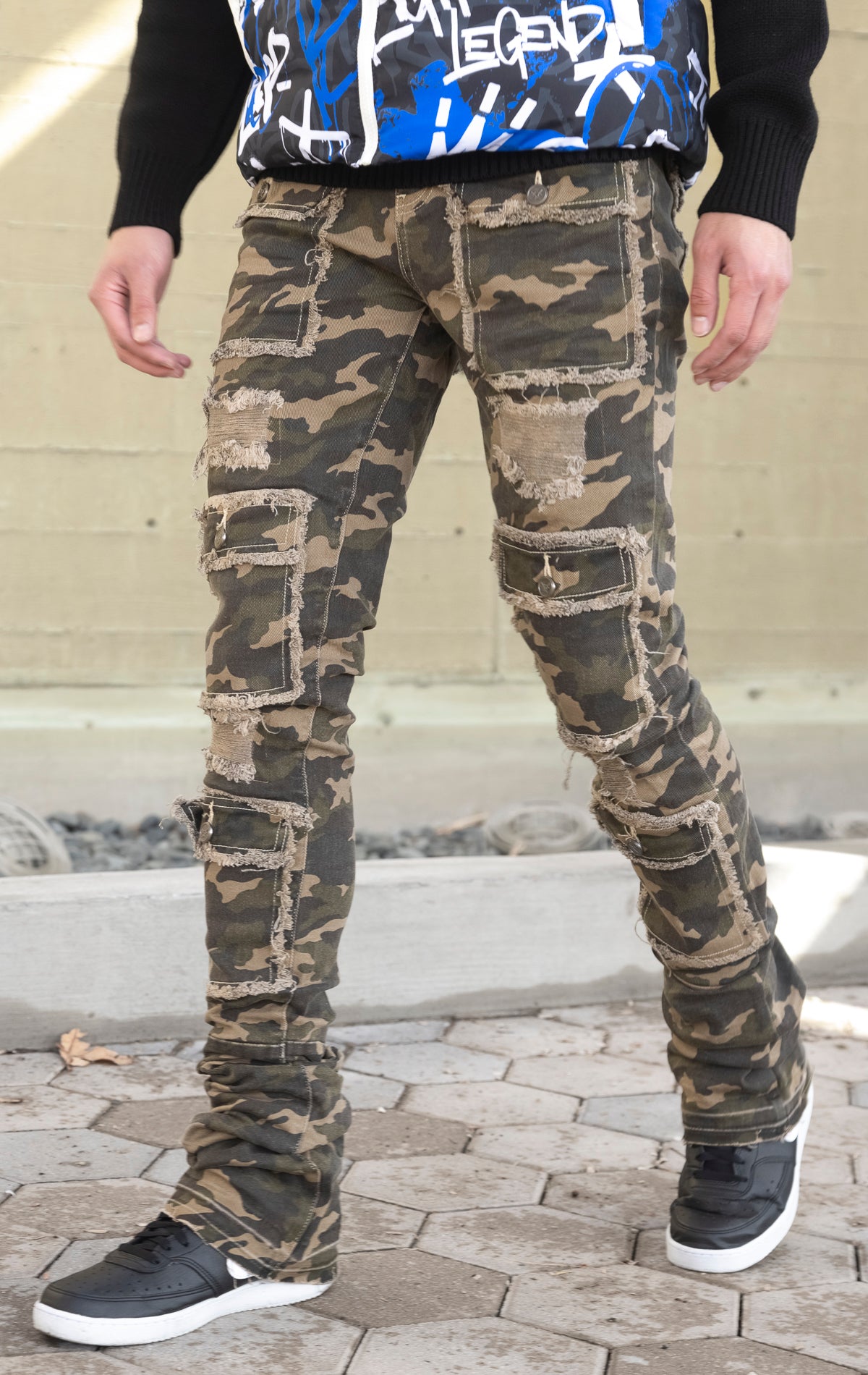 Camo super stacked jeans featuring an extra-long inseam and flared leg opening with distressing, stone washing and frays.
