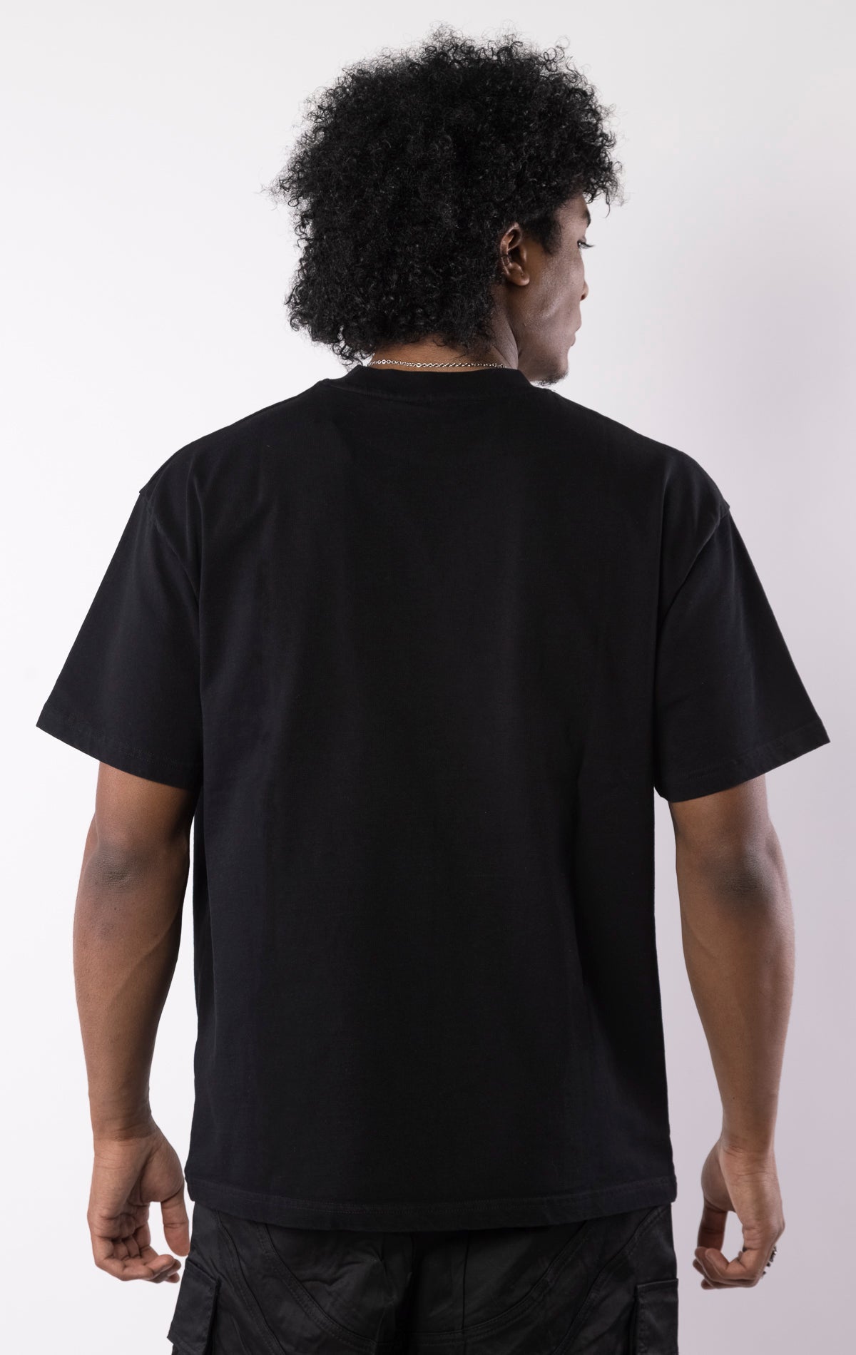 Black t-shirt with a bold graphic of a race-suited rider under a starry night sky, gothic lettering, and a relaxed crewneck fit.