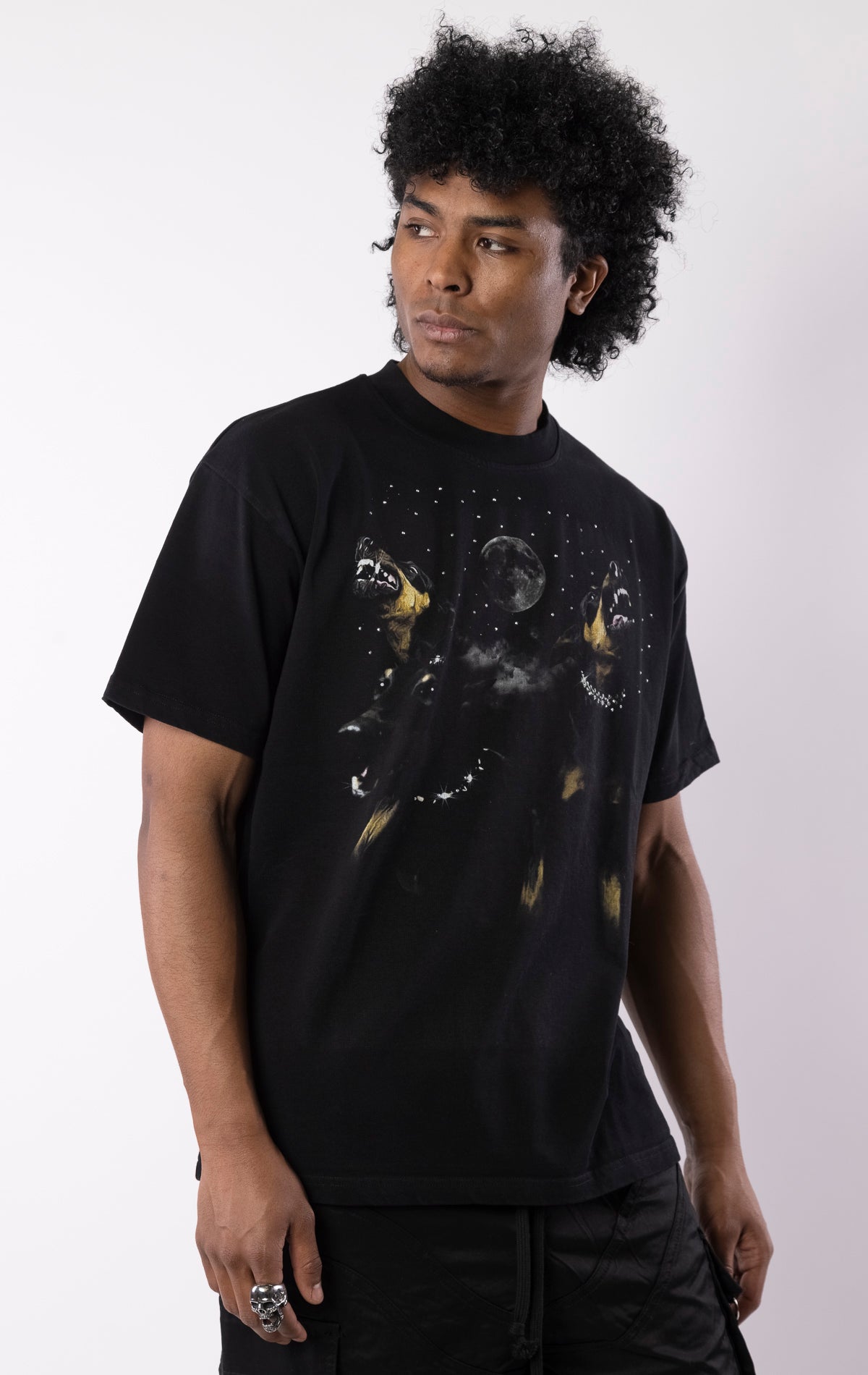 Black t-shirt with snarling dogs graphic under a moon and stars, featuring a bold print on the front and a relaxed crewneck fit.