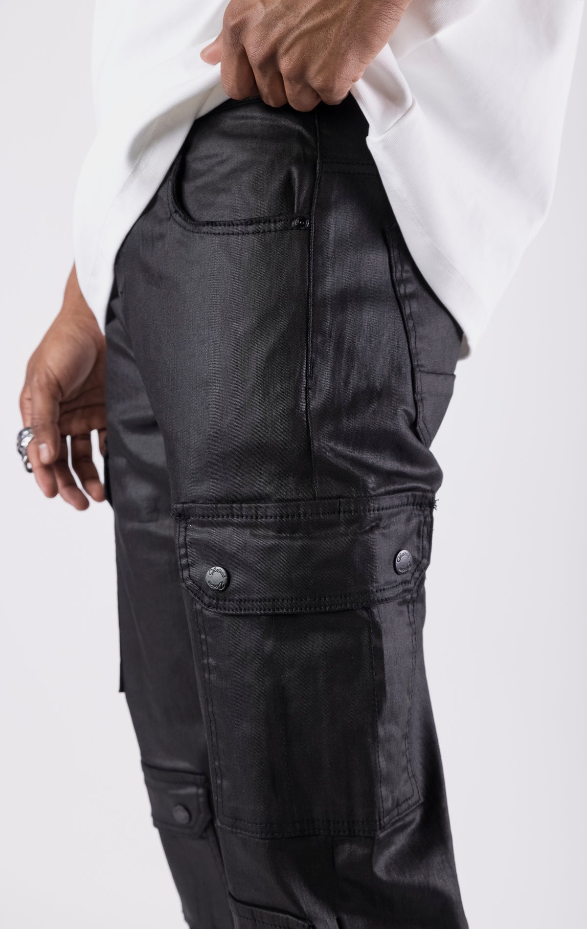 Black wax-coated baggy jeans with multiple cargo pockets and a relaxed fit.