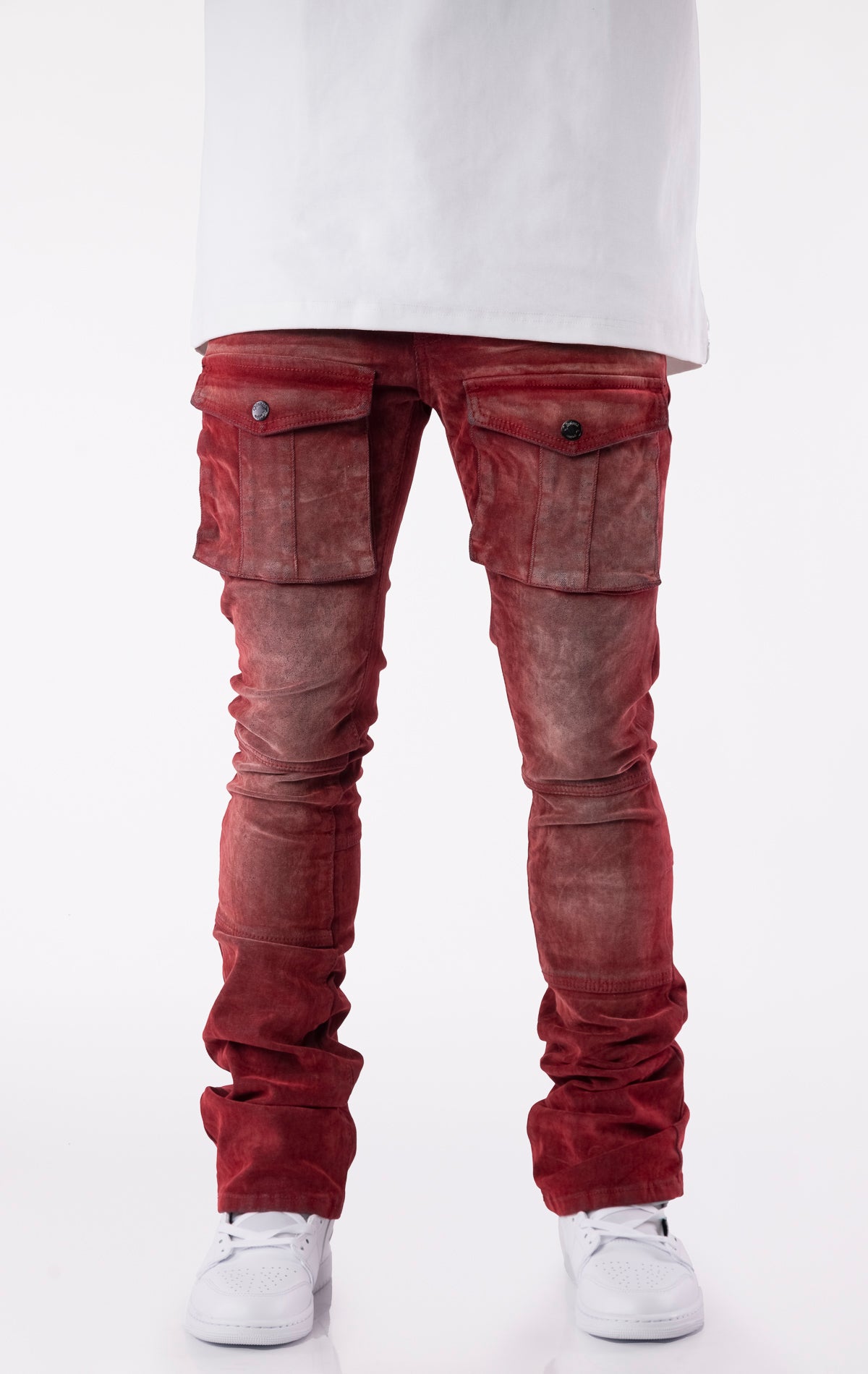 Red velour-coated stacked jeans with oversized cargo pockets, showcasing a soft texture, button closures, and extended length for a stacked ankle look.