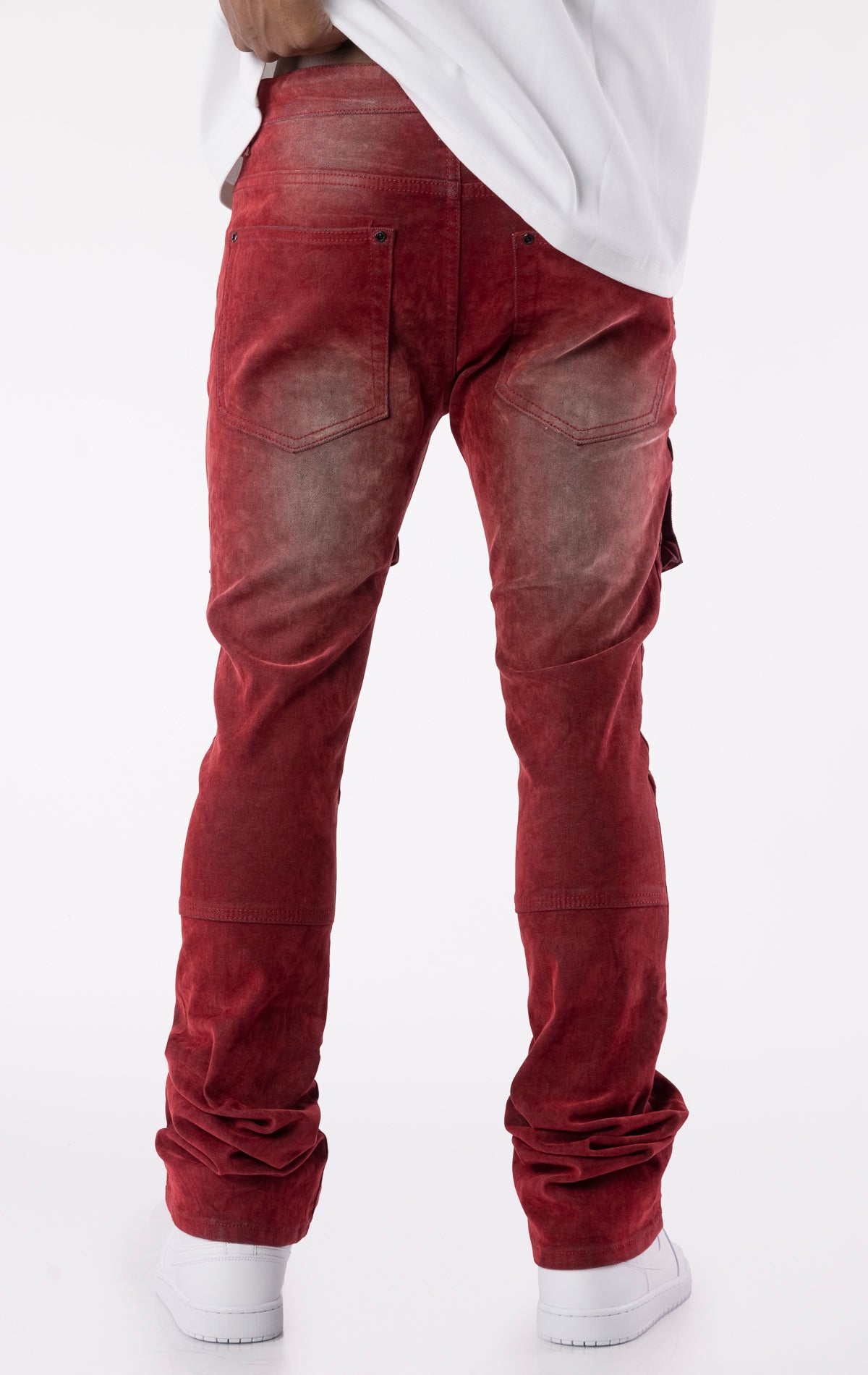 Red velour-coated stacked jeans with oversized cargo pockets, showcasing a soft texture, button closures, and extended length for a stacked ankle look.