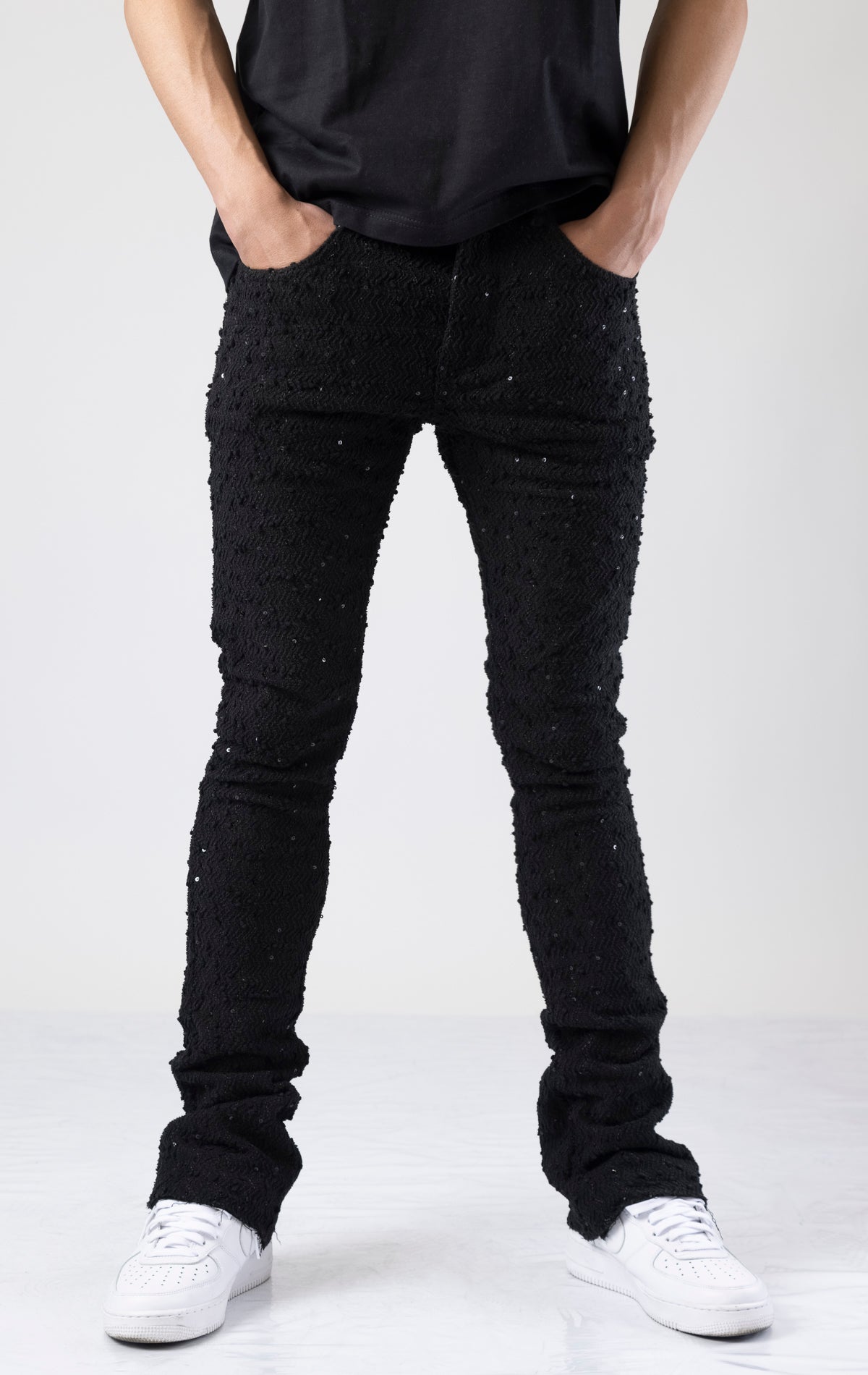 Black embellished stacked flared jeans in black.