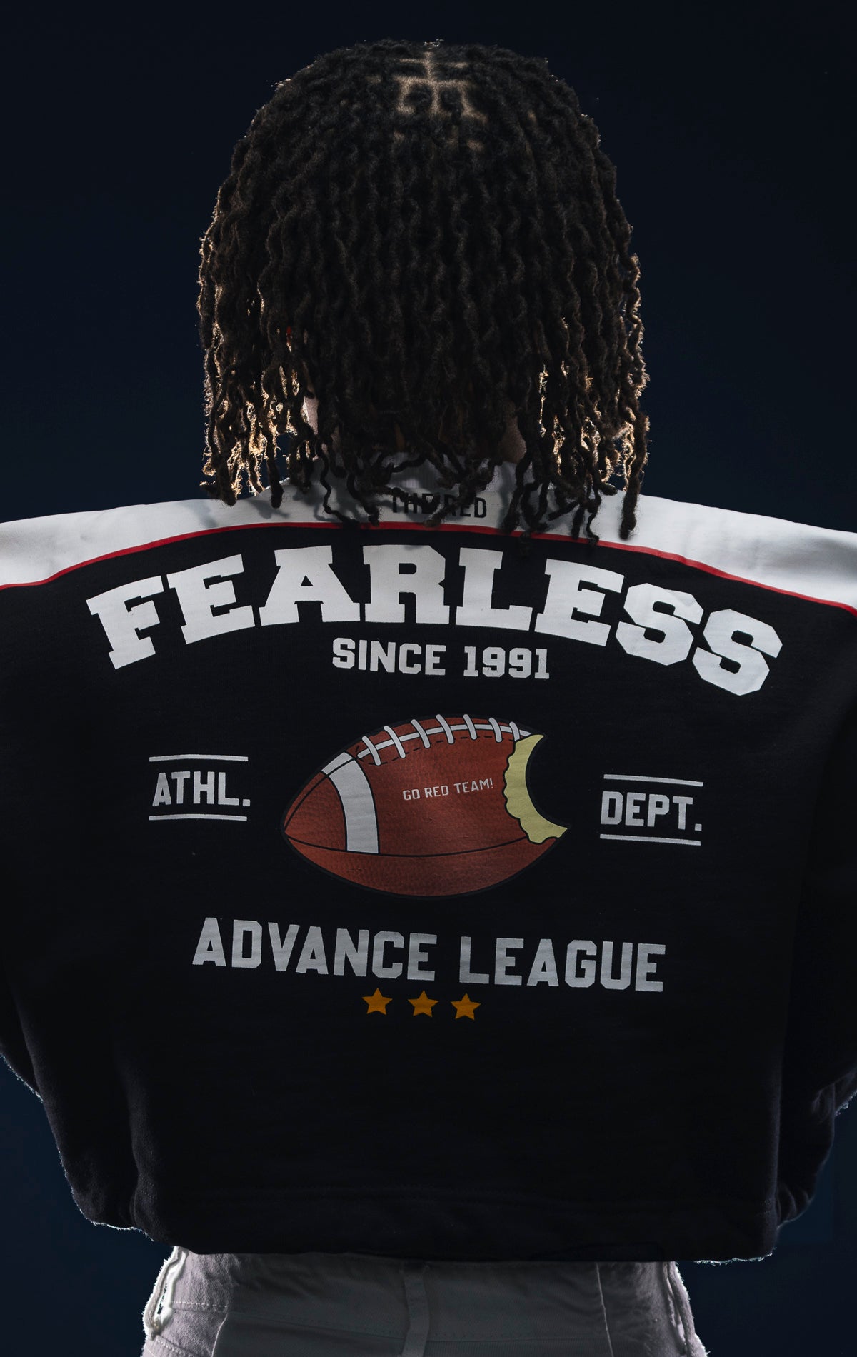 Black fleece crop top with dropped shoulders, double drawstrings, and screen print details. Made from 90% cotton and 10% polyester.