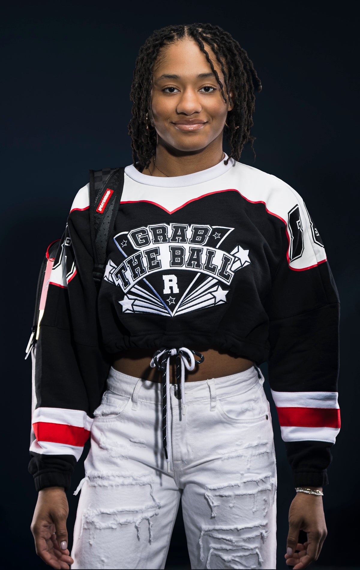 Black fleece crop top with dropped shoulders, double drawstrings, and screen print details. Made from 90% cotton and 10% polyester.