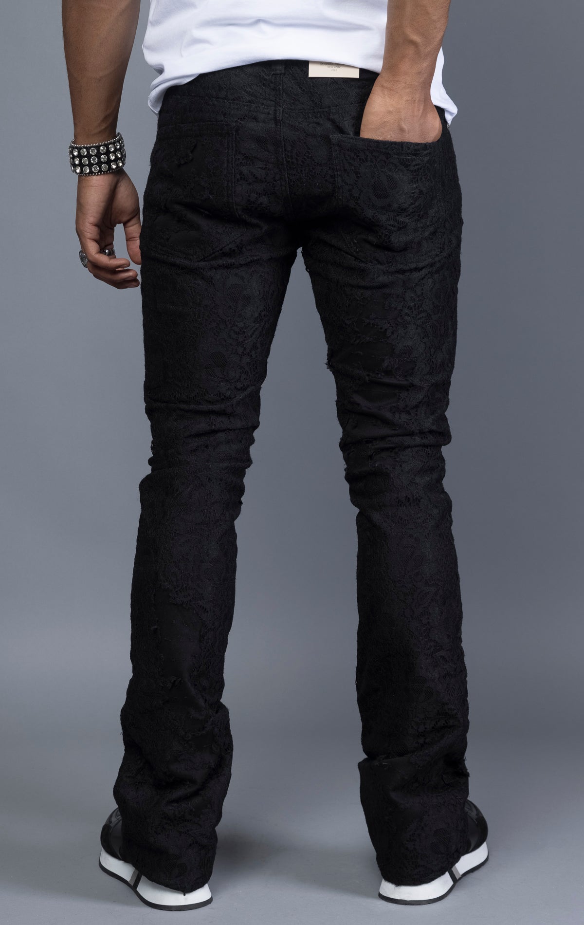 black Mid-rise stacked jeans with lace detailing on the legs.