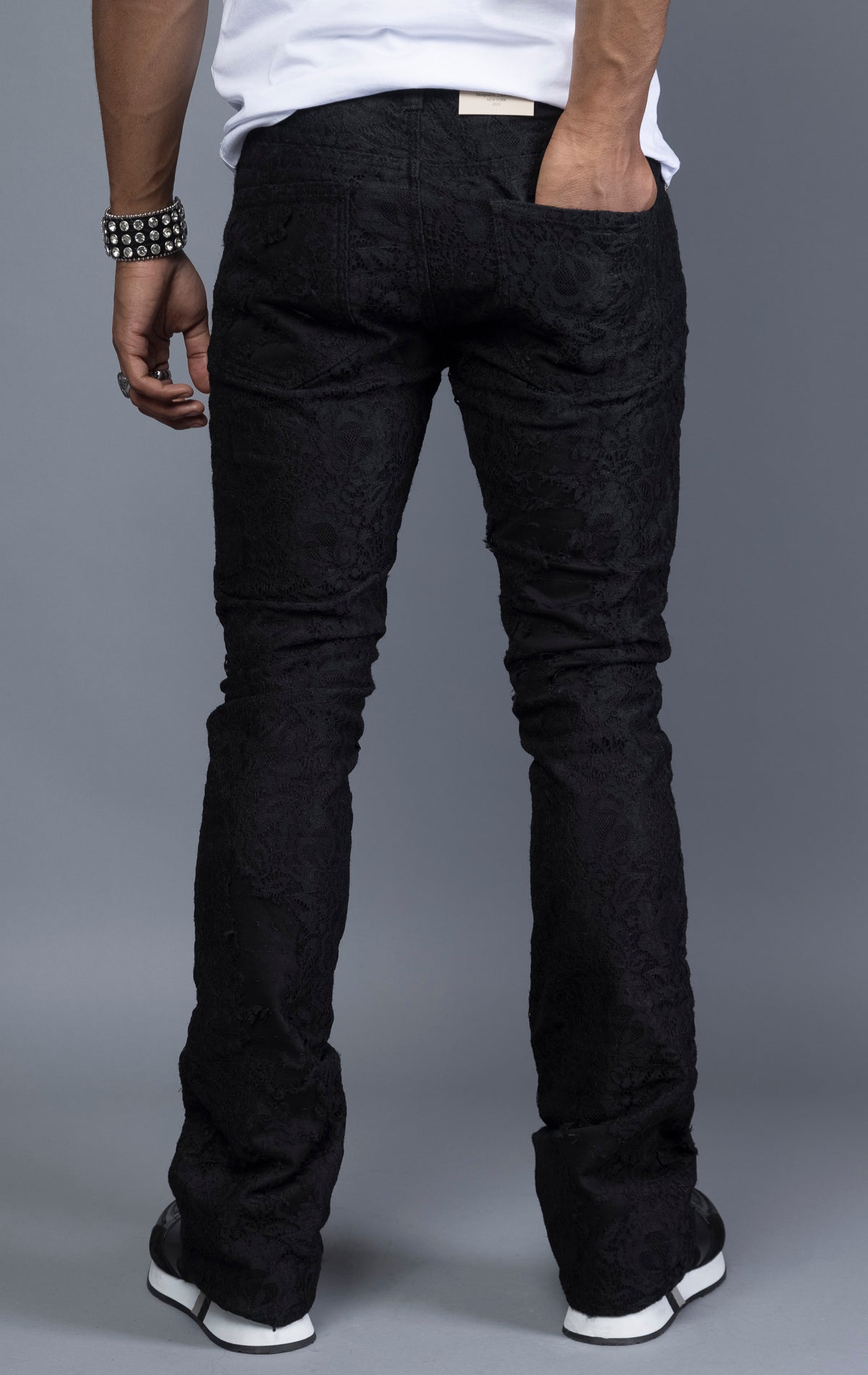 Mid-rise lace stacked leg jeans with a five-pocket design, belt loops, and zipper fly with top button fastening.