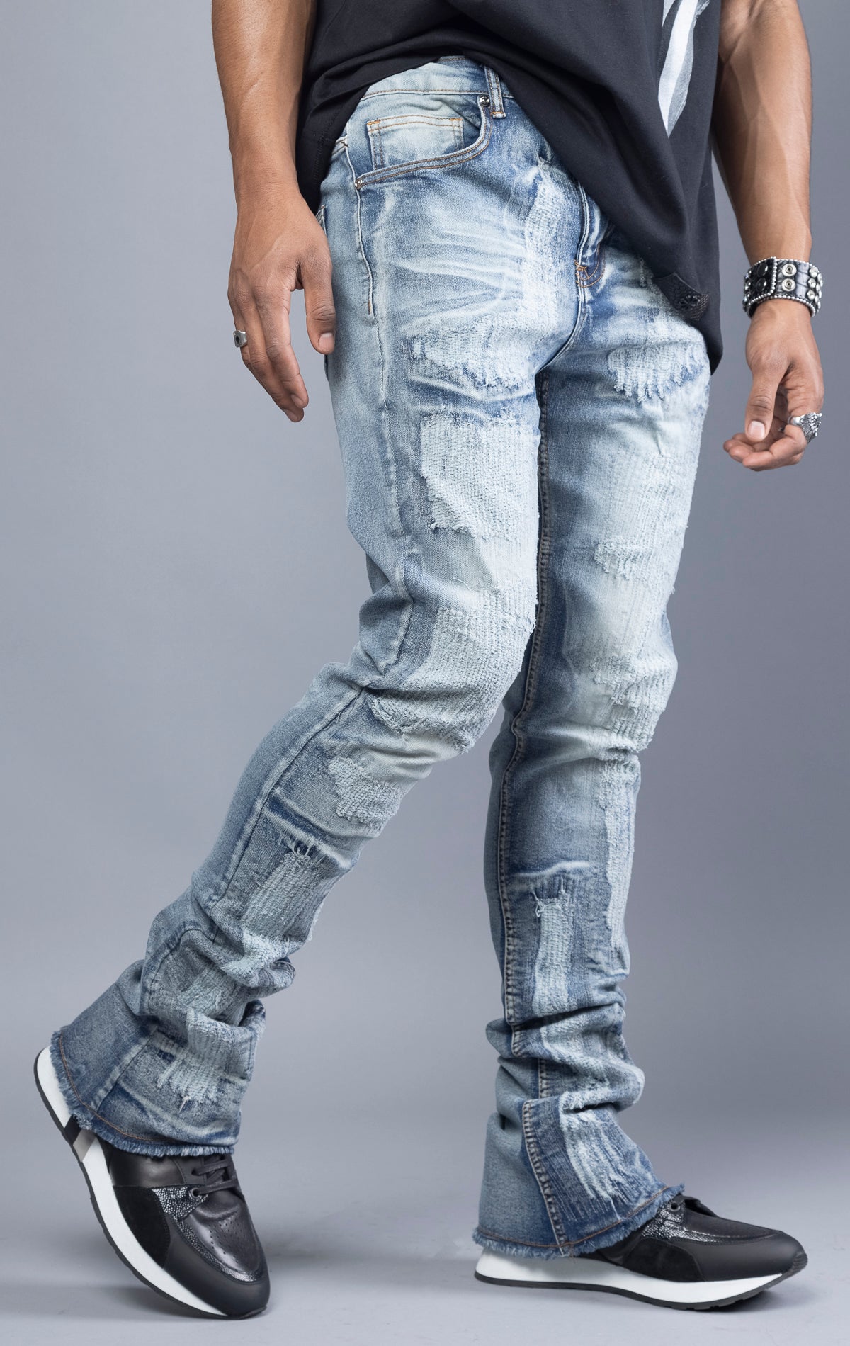 Blue distressed skinny jeans featuring ripped accents throughout the leg and a stacked fit at the ankle for a trendy, edgy look.