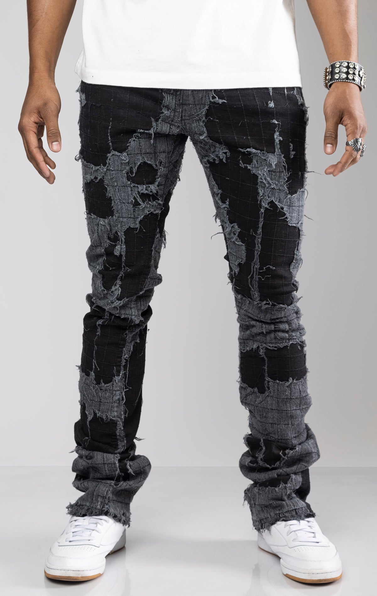 Distressed skinny flare jeans with stacked ankles. Jeans feature all-over gauze patches, intricate stitching, and a ripped and repaired aesthetic.     share   more_vert