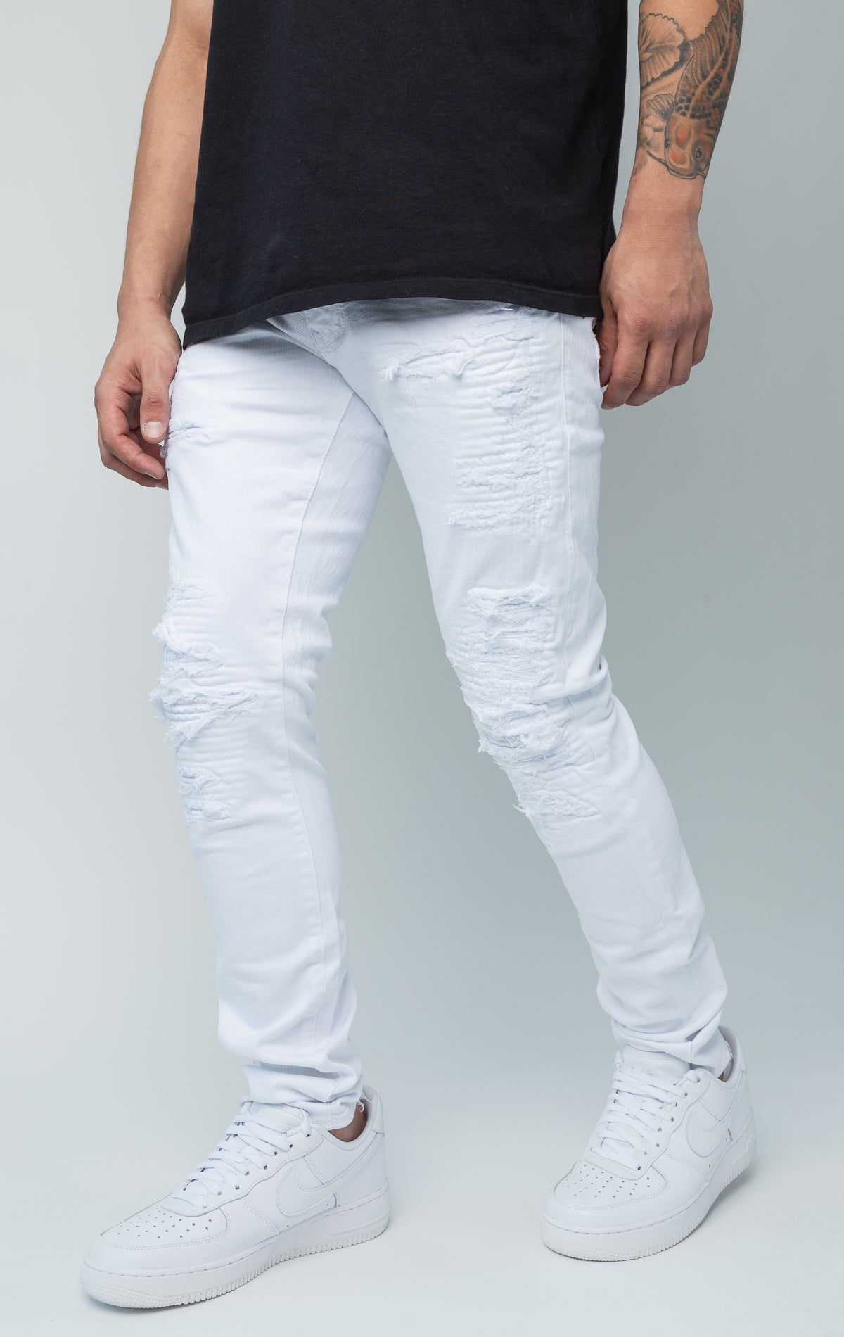 White skinny jeans. Made from a comfortable 98% cotton and 2% lycra blend. Features a regular rise, a tight fit that tapers from the knee to the ankle, hand-formed 3D wrinkles, ripped and repaired design with self-fabric backing, repair stitching, slub twill fabric, intricate detailing, and deep front pockets.