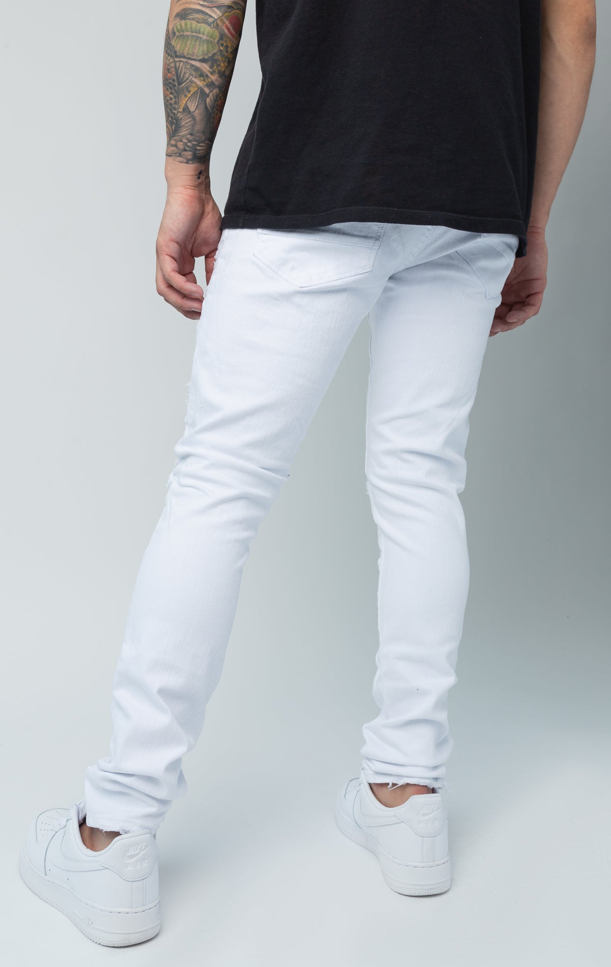 White skinny jeans. Made from a comfortable 98% cotton and 2% lycra blend. Features a regular rise, a tight fit that tapers from the knee to the ankle, hand-formed 3D wrinkles, ripped and repaired design with self-fabric backing, repair stitching, slub twill fabric, intricate detailing, and deep front pockets.