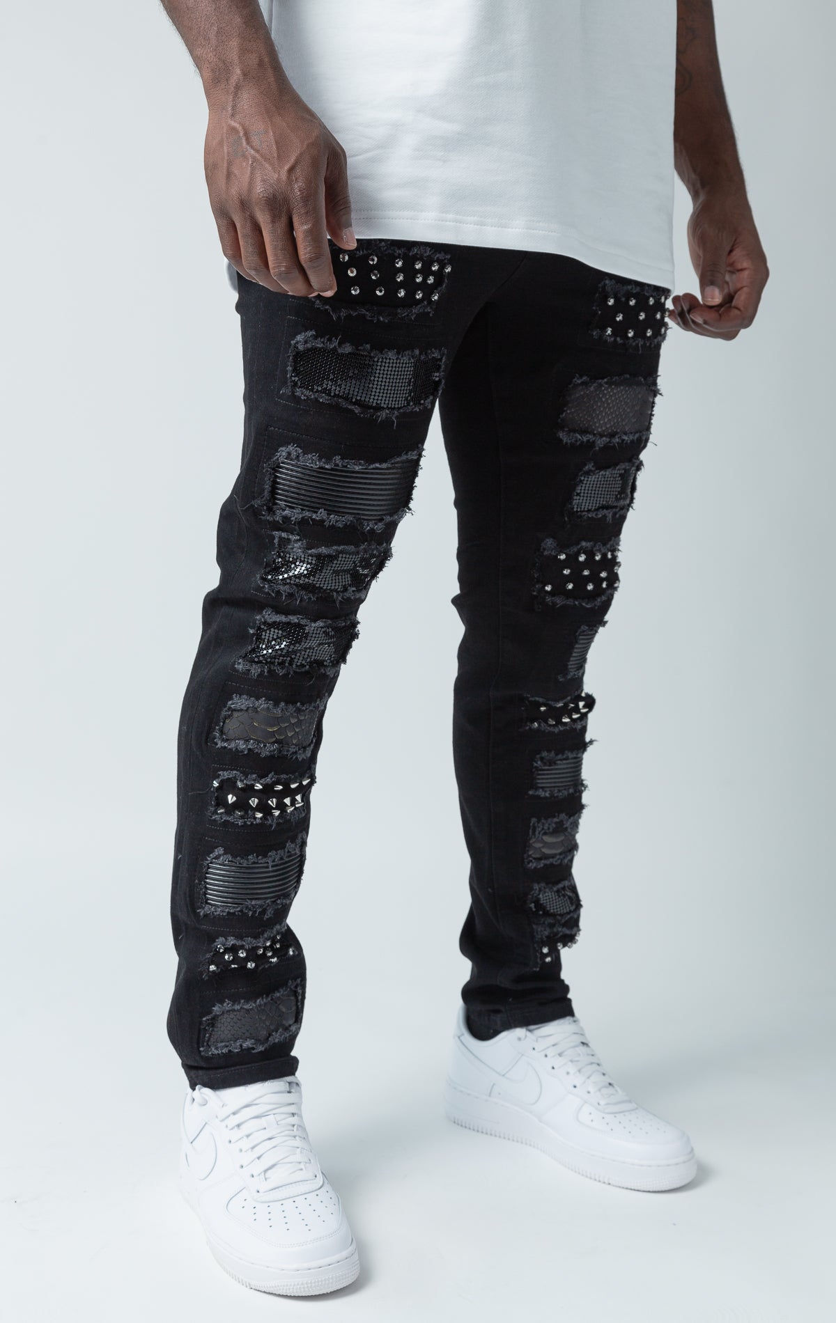 Black distressed denim jeans with rhinestones and studs