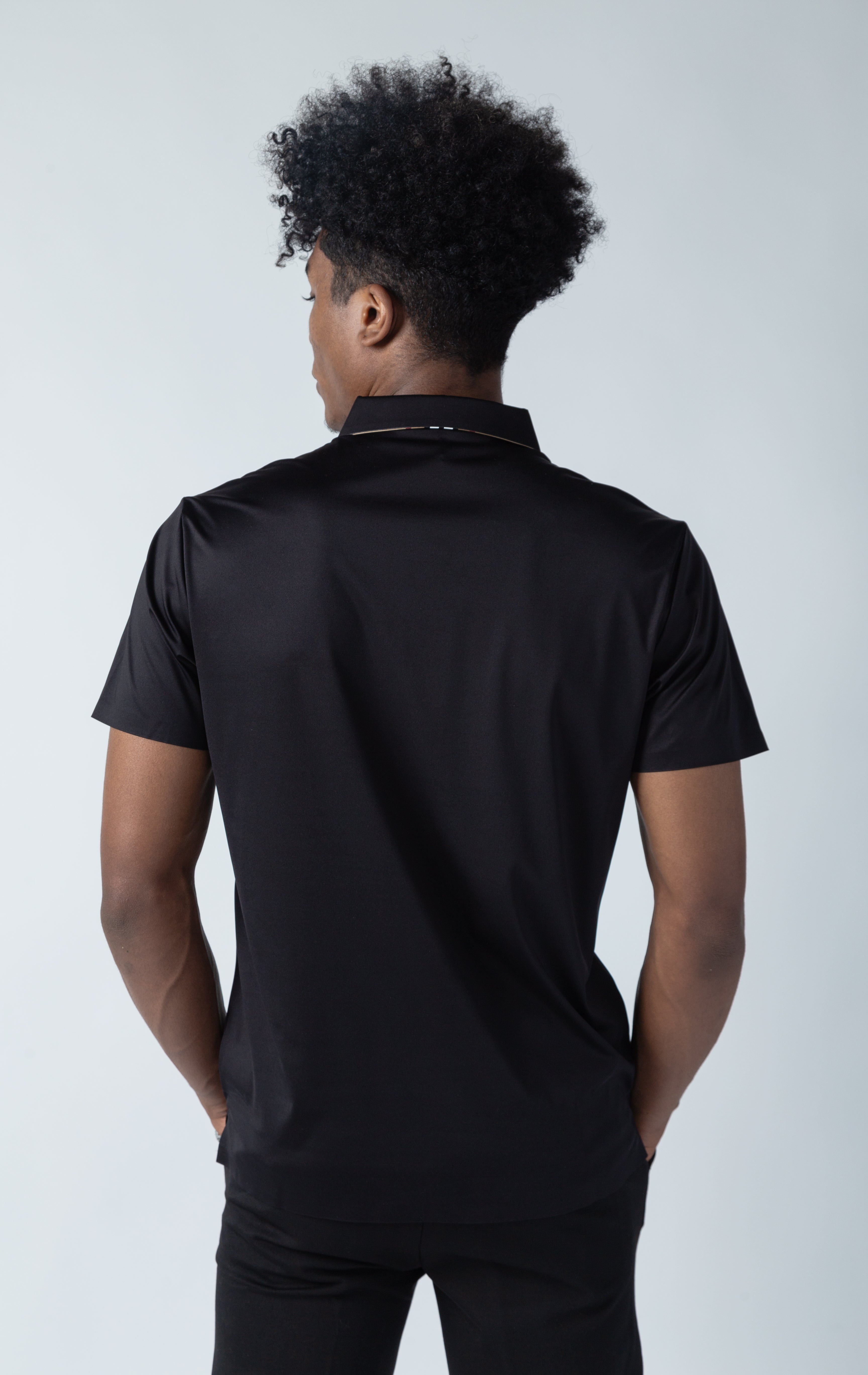 Black polo shirt with a line on the collar and 3 buttons closure collar with a contrasted accent.