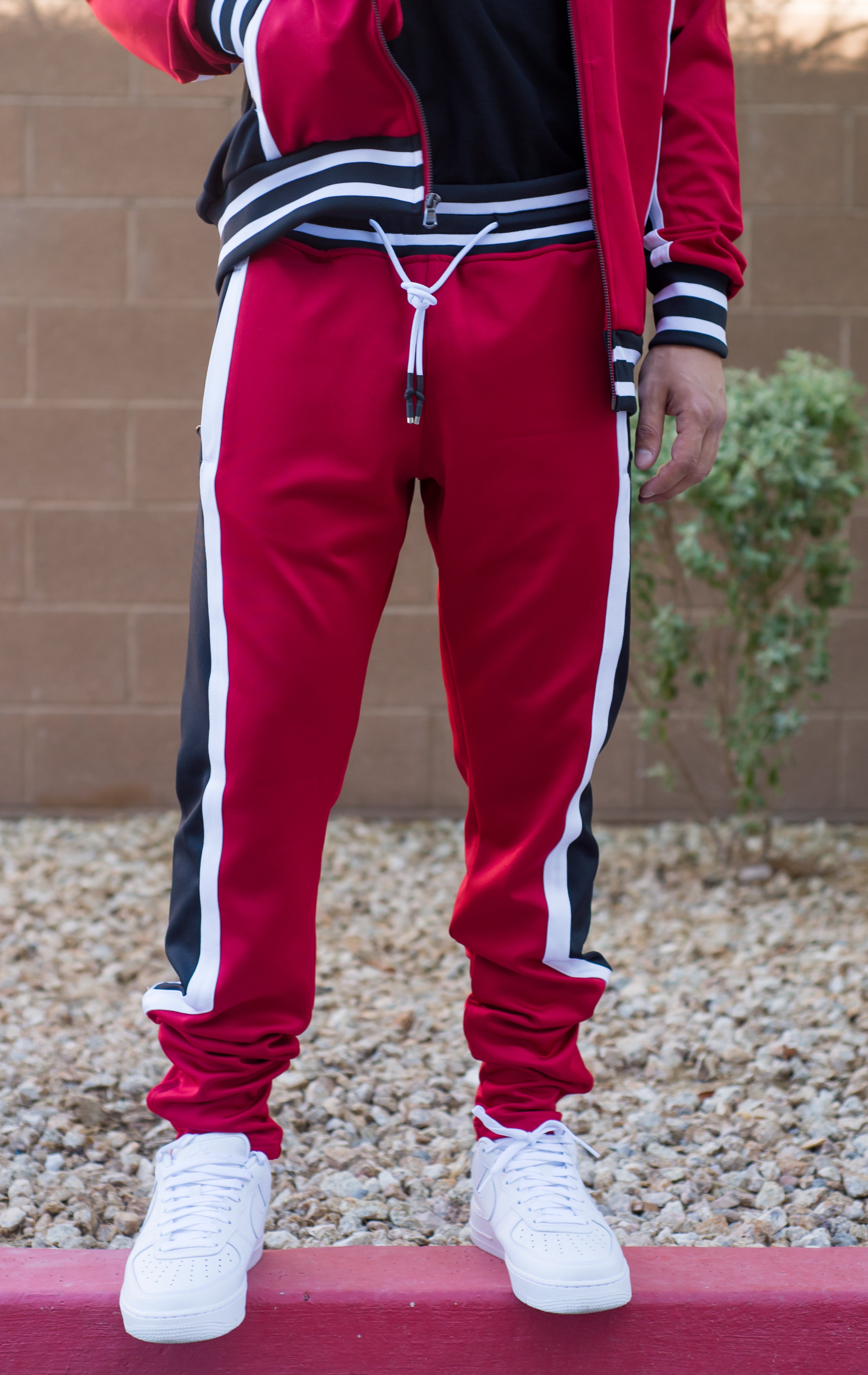 Track suit bottom: Tapered-leg track pant silhouette, rubber dipped drawstrings with metal tips. Dual pockets at sides and zipper gussets at both inner ankle openings.