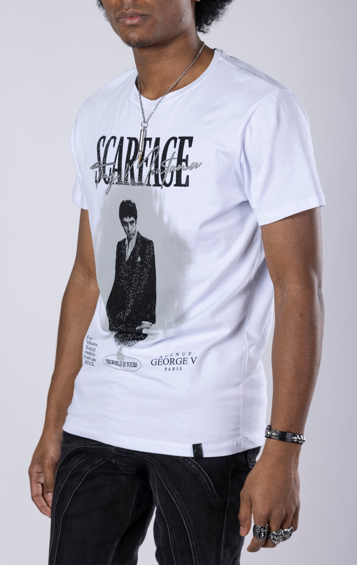 White Scarface Crewneck Tee. Features a crewneck, short sleeves, and a bold Scarface graphic. Made from a blend of 95% cotton and 5% lycra.
