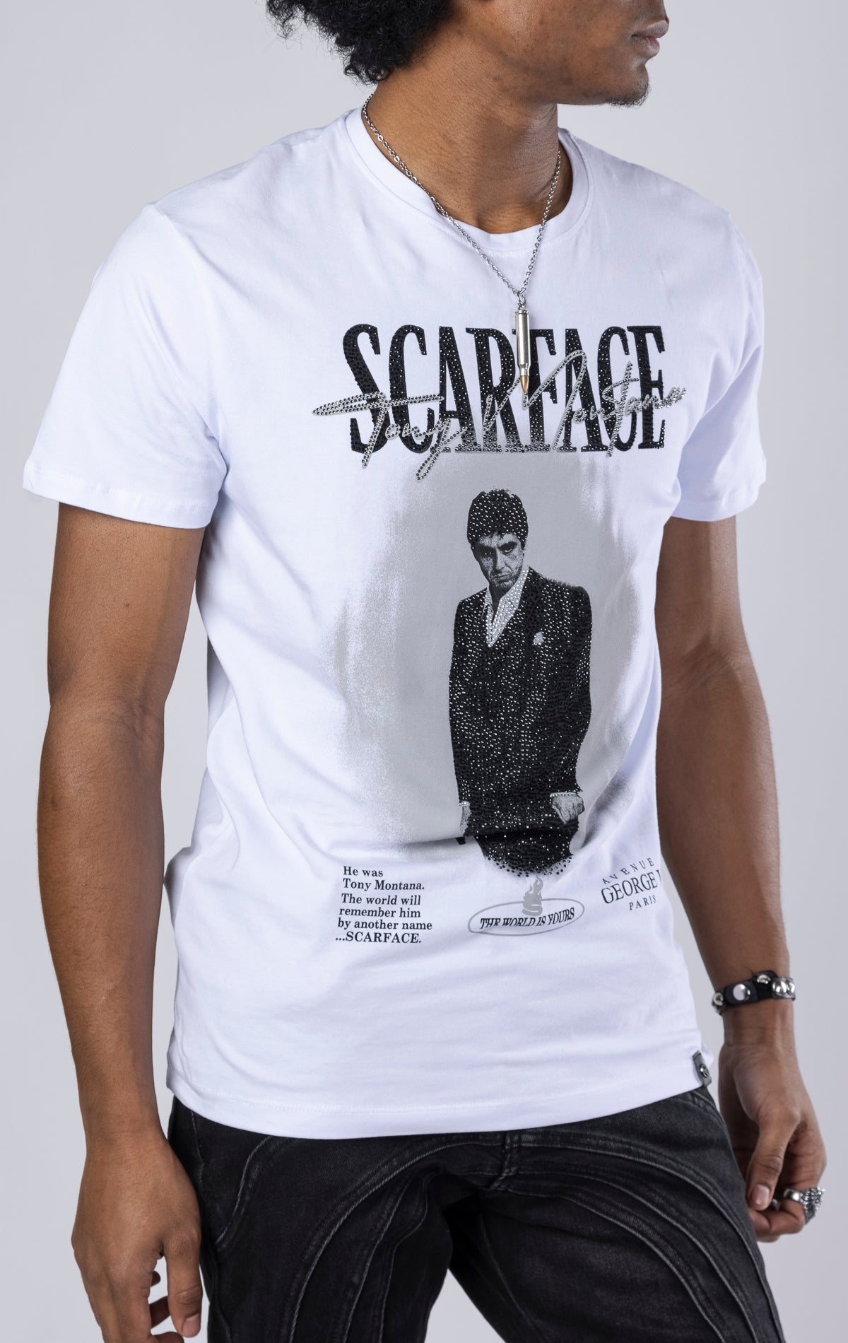 White Scarface Crewneck Tee. Features a crewneck, short sleeves, and a bold Scarface graphic. Made from a blend of 95% cotton and 5% lycra.