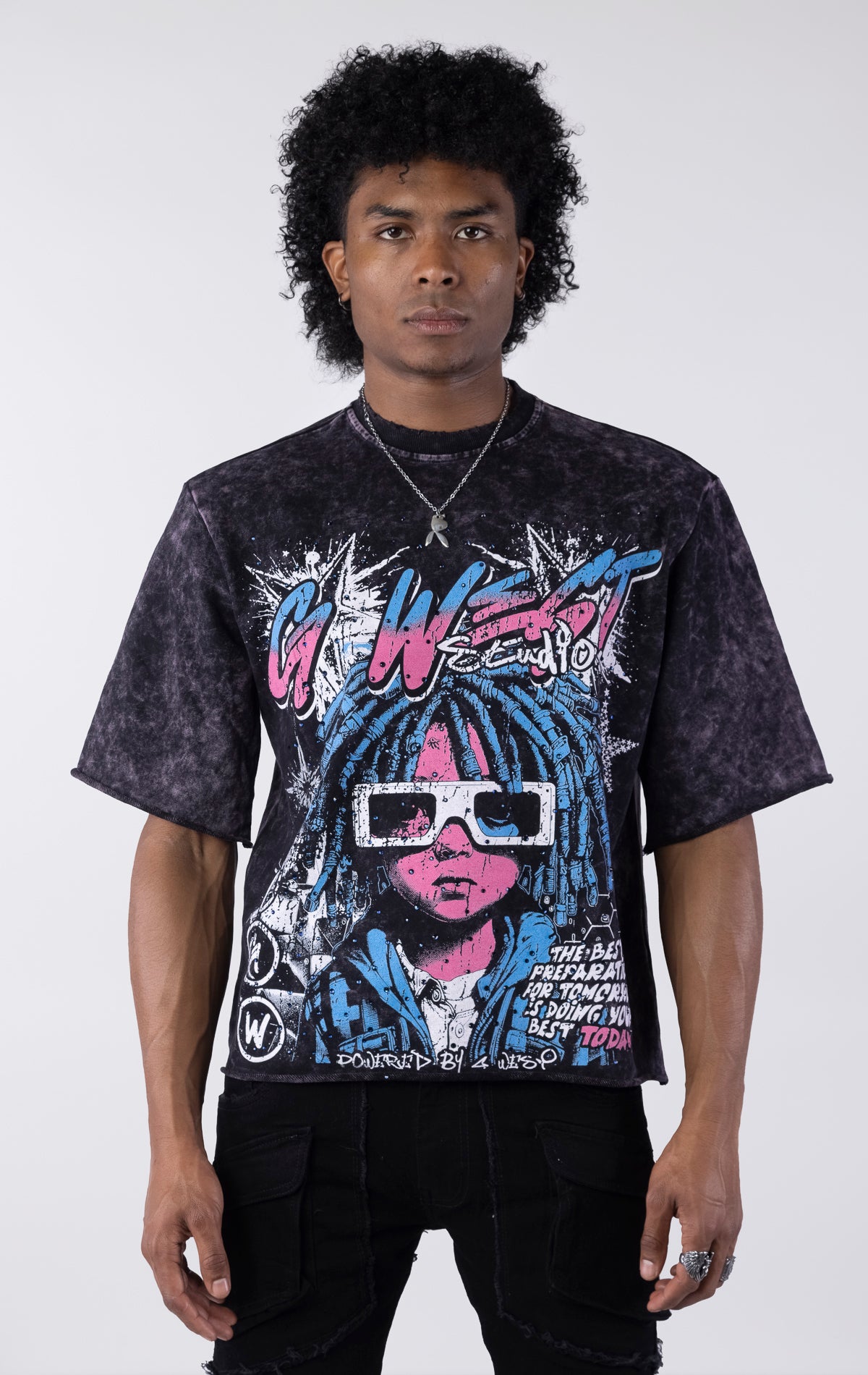 Washed black/purple oversized t-shirt featuring a large graphic of a figure with blue dreadlocks and white 3D glasses. The graphic includes the text "G-WEST Studios" and "THE BEST PREPARATION FOR TOMORROW IS DOING YOUR BEST TODAY!" accented with rhinestones.