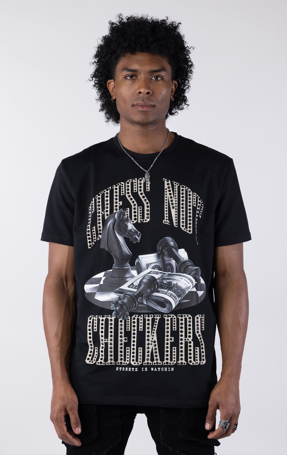 Black t-shirt with a large graphic featuring a black chess knight, fallen pawns, and stacks of money on a checkered surface. The text 