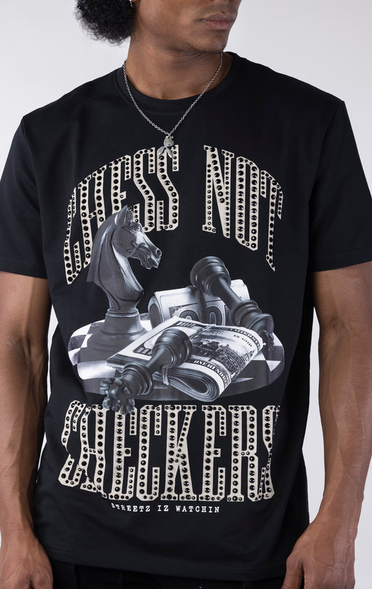 Black t-shirt with a large graphic featuring a black chess knight, fallen pawns, and stacks of money on a checkered surface. The text "CHESS NOT" and "CHECKERS" is printed above and below the graphic in a sparkling white-outlined font.