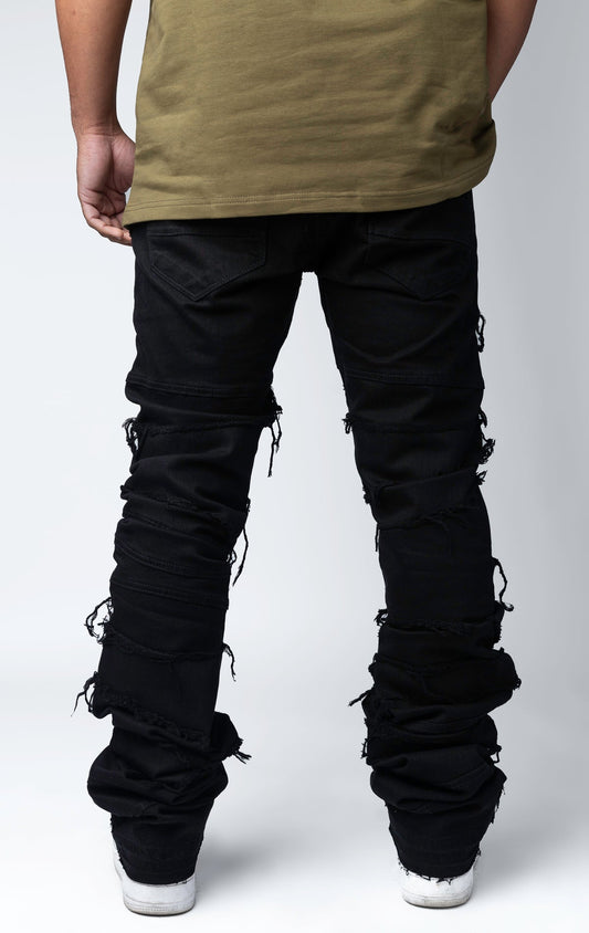 Edgy flare jeans feature a unique heavy wash, rip and repair design, and patches and abrasions throughout.