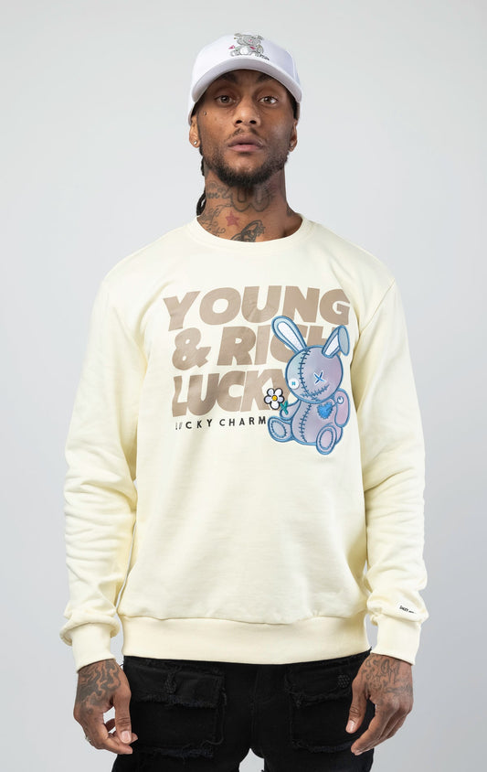Off white stylish and comfortable sweatshirt featuring a vibrant lucky charm bunny print and an empowering 'Young, Rich, and Lucky' slogan.