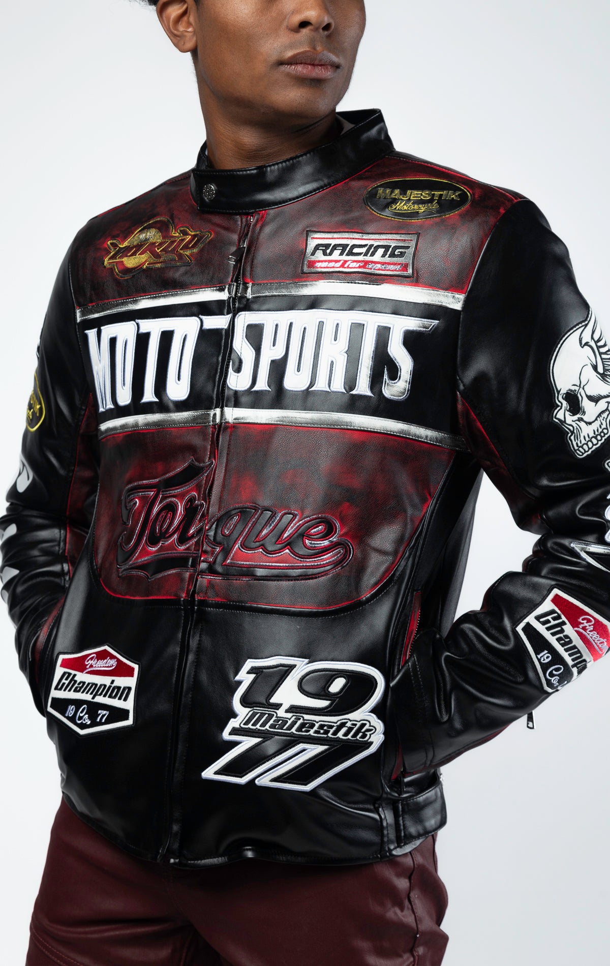Black motor sport racing jacket with  snap-button collar, full zip-up closure, multi-patch and embroidered details, zippered sleeves and pockets, and elasticized ribbed collar, cuffs, and waist. The interior includes a hanger loop, welt pocket, and faux leather finish for added convenience.