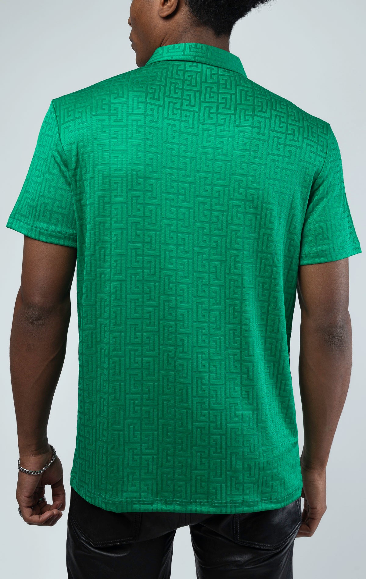 Green This polo shirt is made with Greek key textured fabric. Features a pointed collar, quarter zip-up closure, and short sleeves.