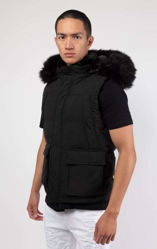 Black Faux fur-lined hooded jacket made of a water-resistant polyester shell featuring a removable hood with a removable faux fox fur trim. The hood and front of the jacket are lined with faux rabbit fur for superior warmth. The jacket has JC branded zippers throughout, dual pockets at the sides with button openings, and a full zipper front opening. Faux suede taping adorns the front zipper.