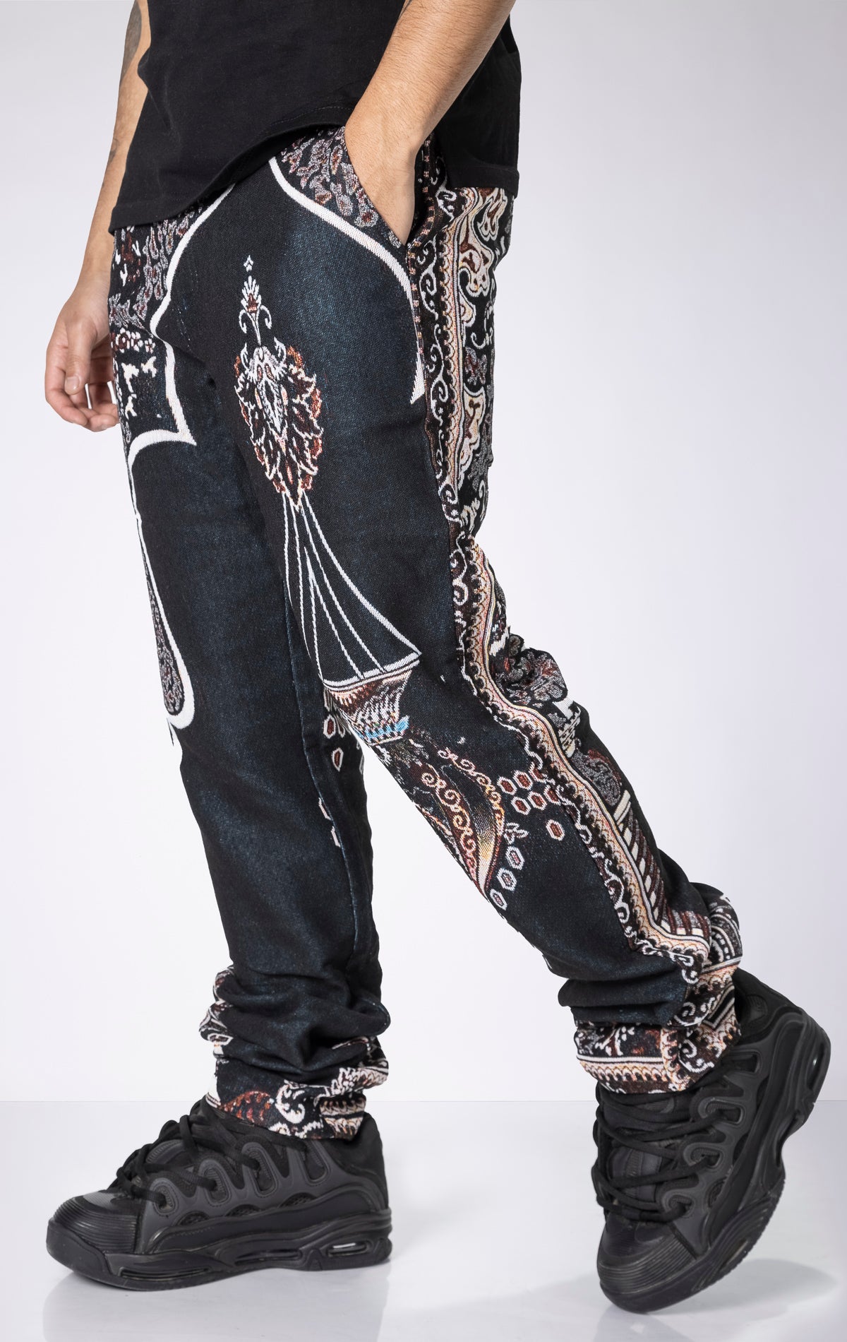 Persian Tapestry Pants. Made from 100% luxury cotton for superior comfort. Features a straight leg fit, allover tapestry print, cargo pockets, fringe accents, and custom hardware.