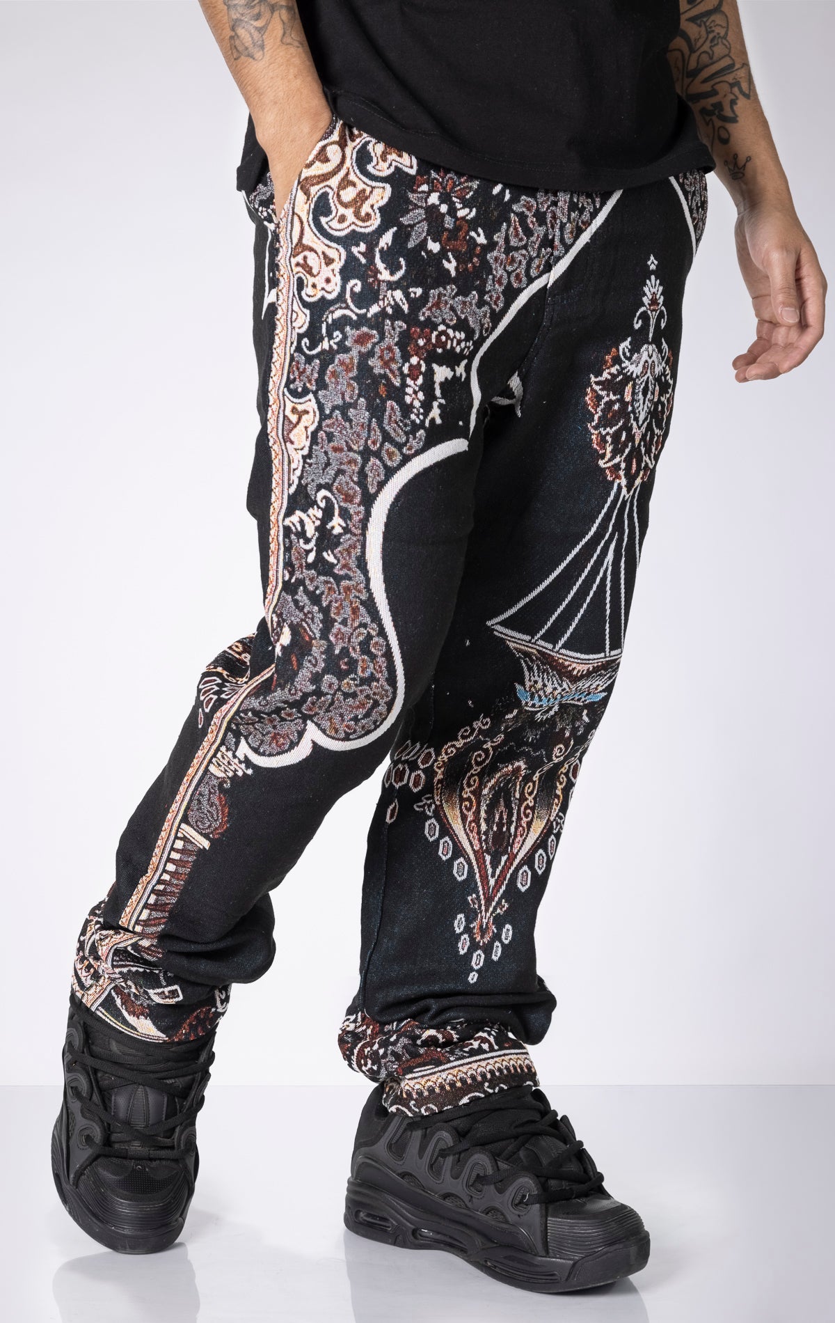 Persian Tapestry Pants. Made from 100% luxury cotton for superior comfort. Features a straight leg fit, allover tapestry print, cargo pockets, fringe accents, and custom hardware.