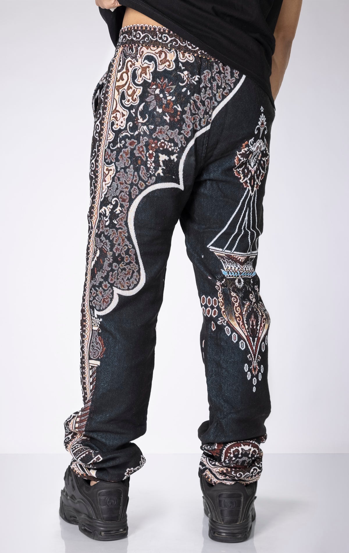 Persian Tapestry Pants. Made from 100% luxury cotton for superior comfort. Features a straight leg fit, allover tapestry print, cargo pockets, fringe accents, and custom hardware.