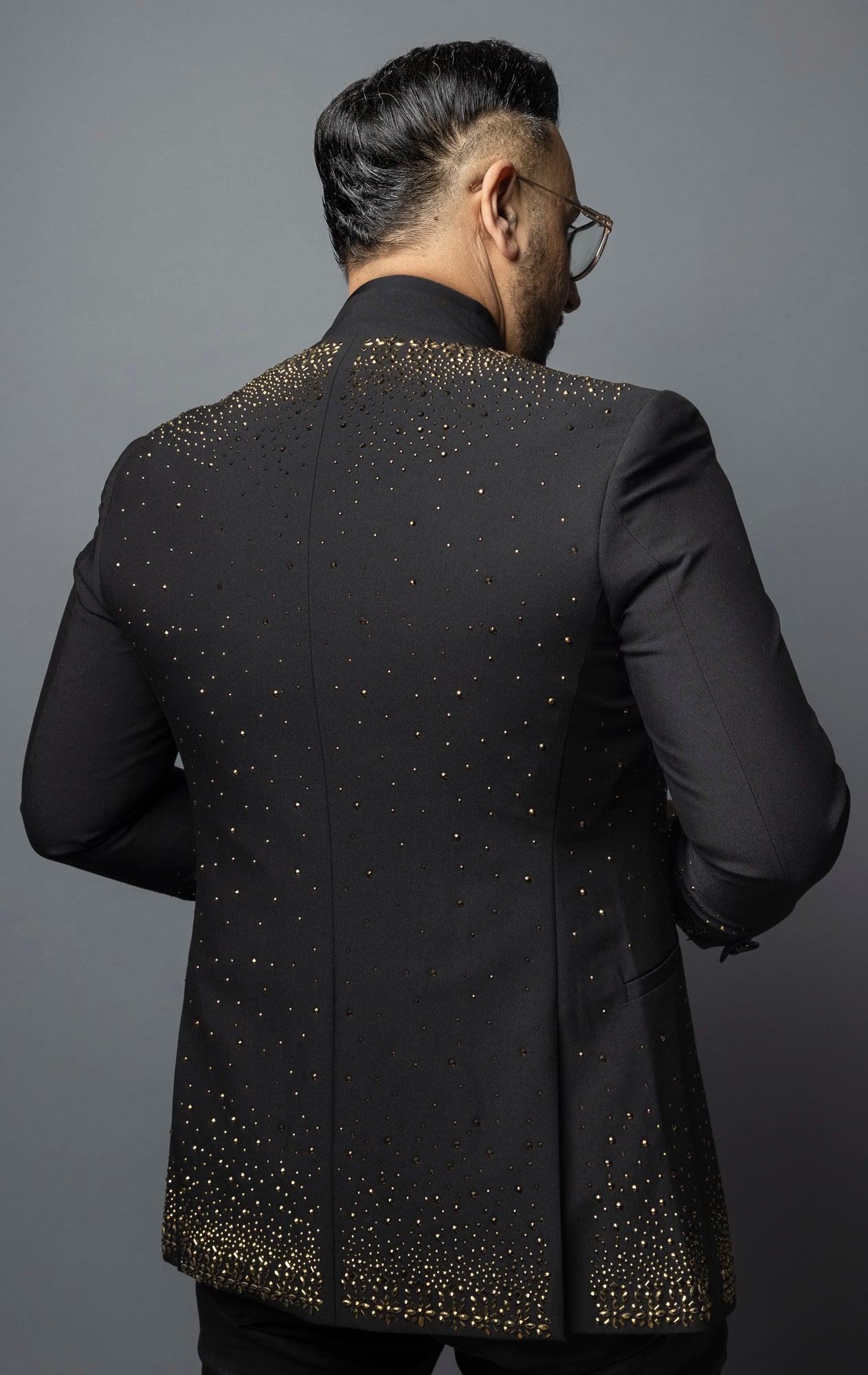 Black blazer featuring a solid color and striking gold rhinestone design, with a band collar