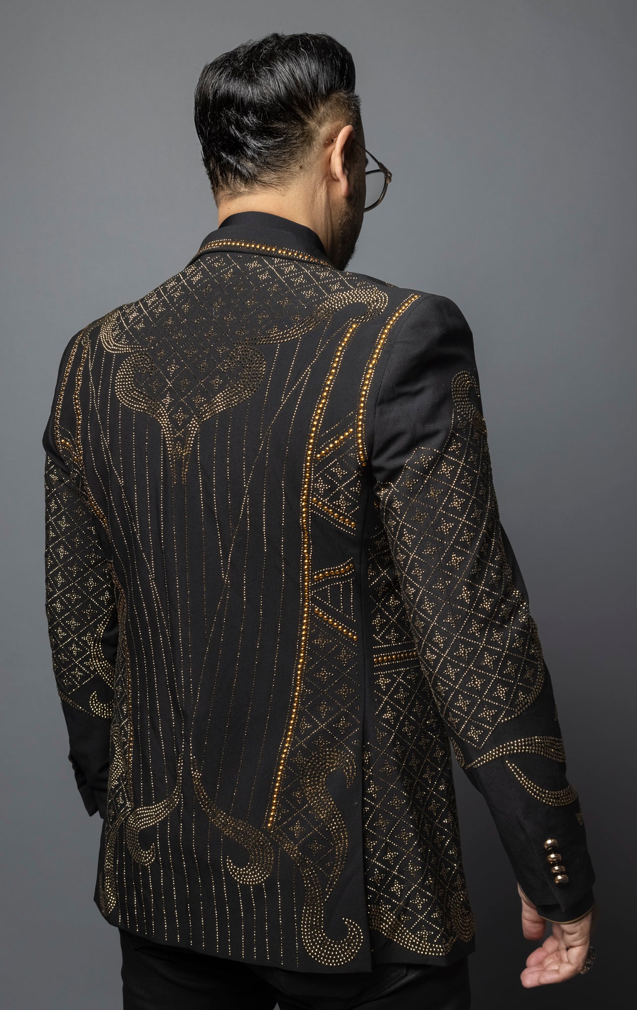 Exuding elegance, this blazer features a unique design embellished with gold rhinestones and a sleek cut.